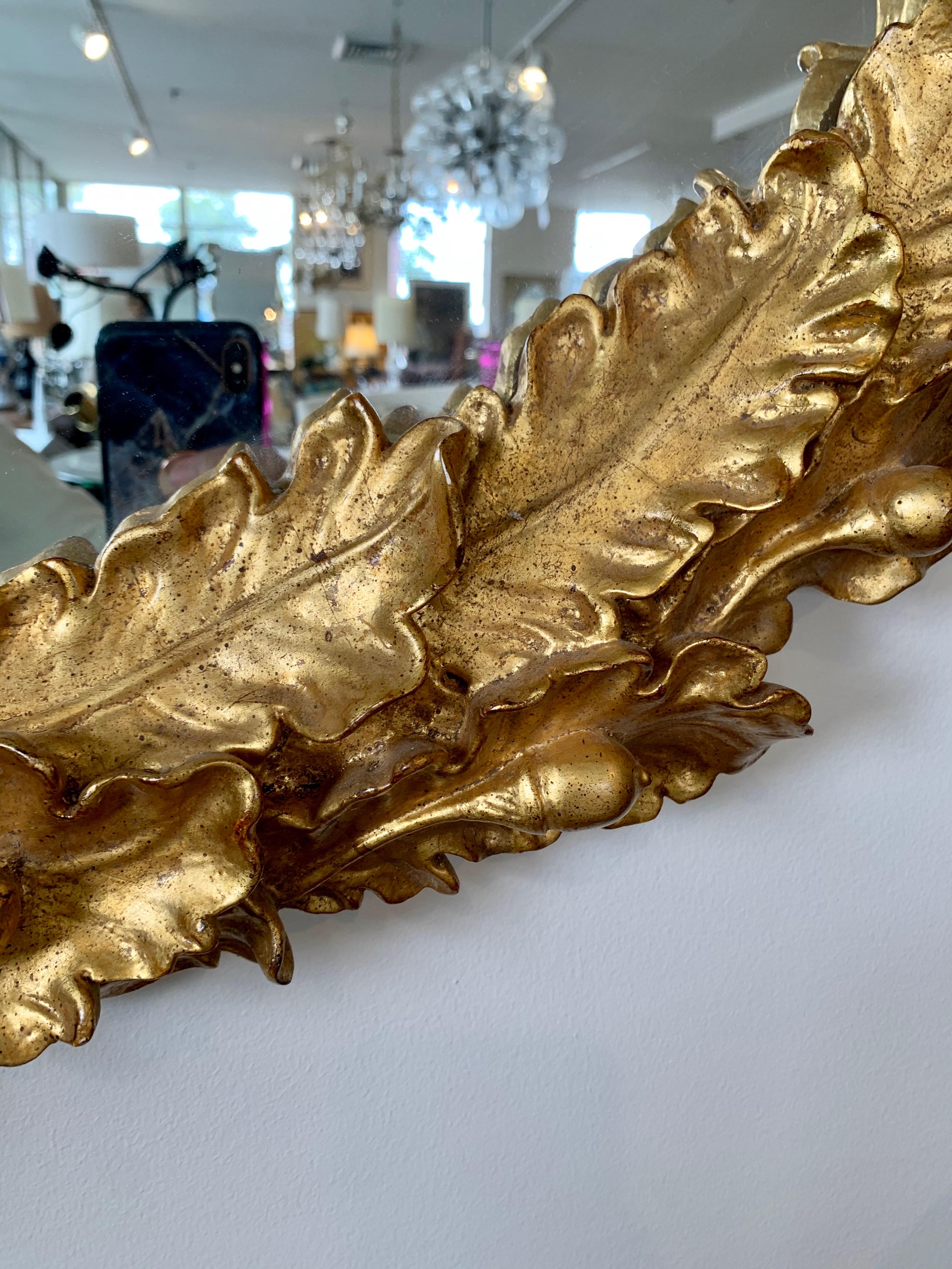 Magnificent large intricately carved gold giltwood Louis XVI style oval mirror measures 4ft. x 3 ft. and features carved giltwood oak leaves and acorns.