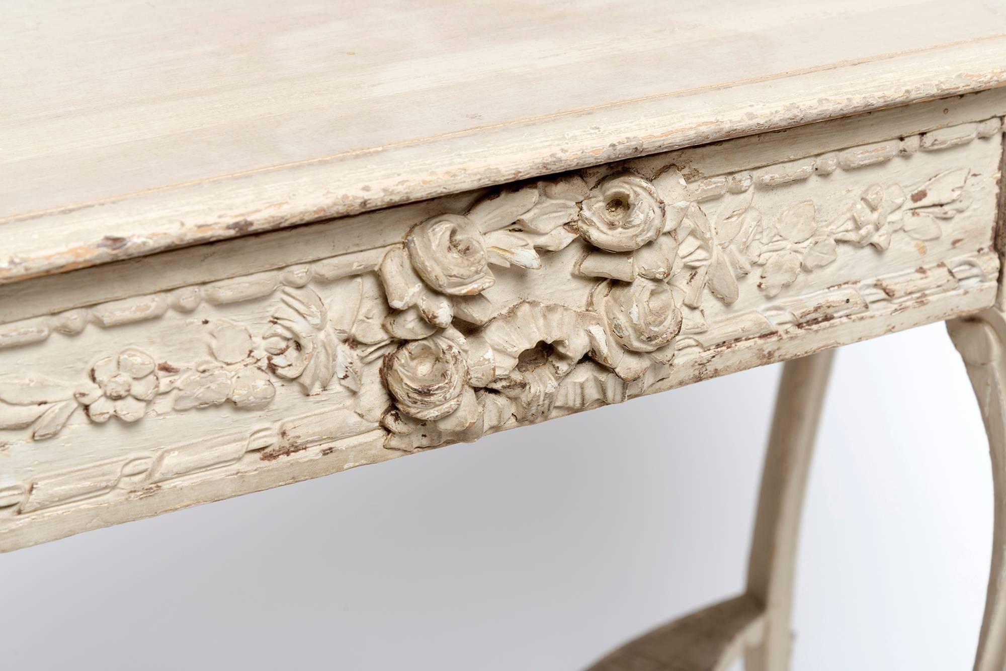 A lovely hand-carved French, Louis XVI table with intricate details and one center drawer.