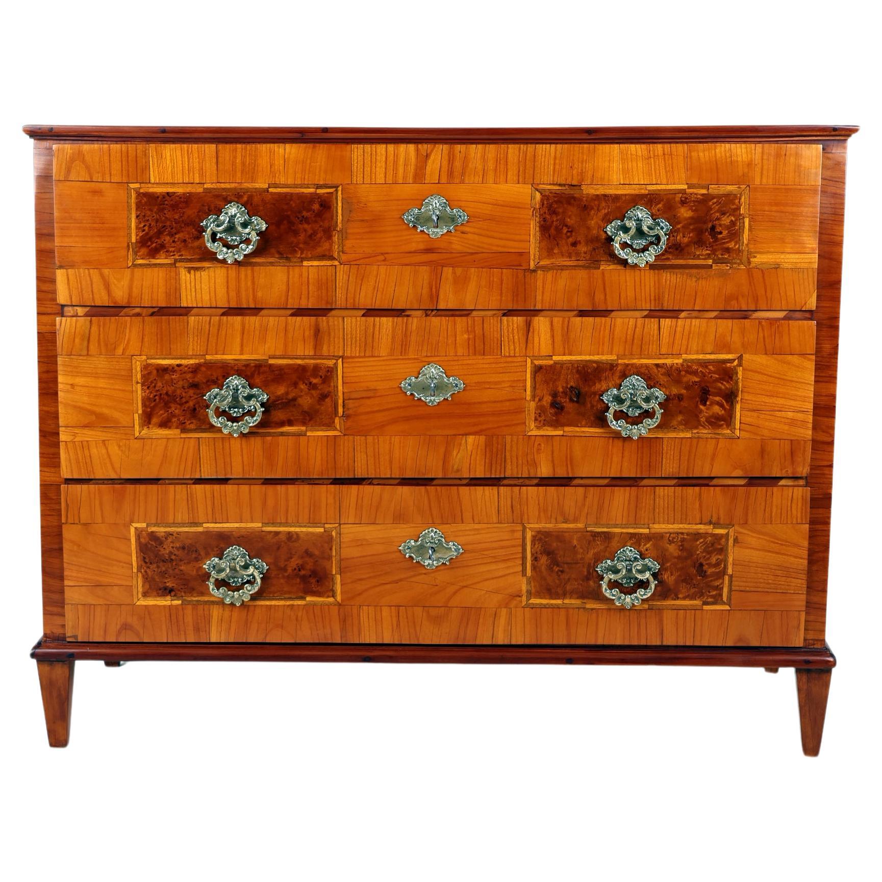 Louis XVI Chest of drawers from early 19th century , 
Germany, 1800
Cherry wood

This Louis XVI cherrywood chest of drawers is an original from 1800 and features three drawers with brass handles. With a length of 52 cm, a width of 117 cm and a