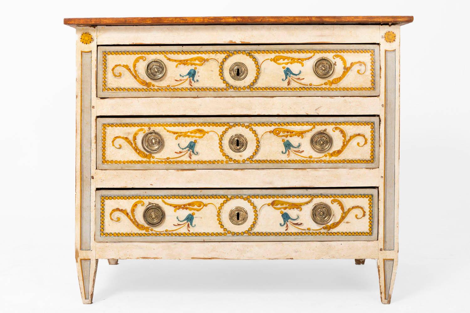 Commode in cream color painted wood standing on four sheath legs and opening by three front opening thanks to two chiselled and gilt bronze circular handles, keyholes and medallions. 
Front of drawers and lateral panels decorated in a blue and