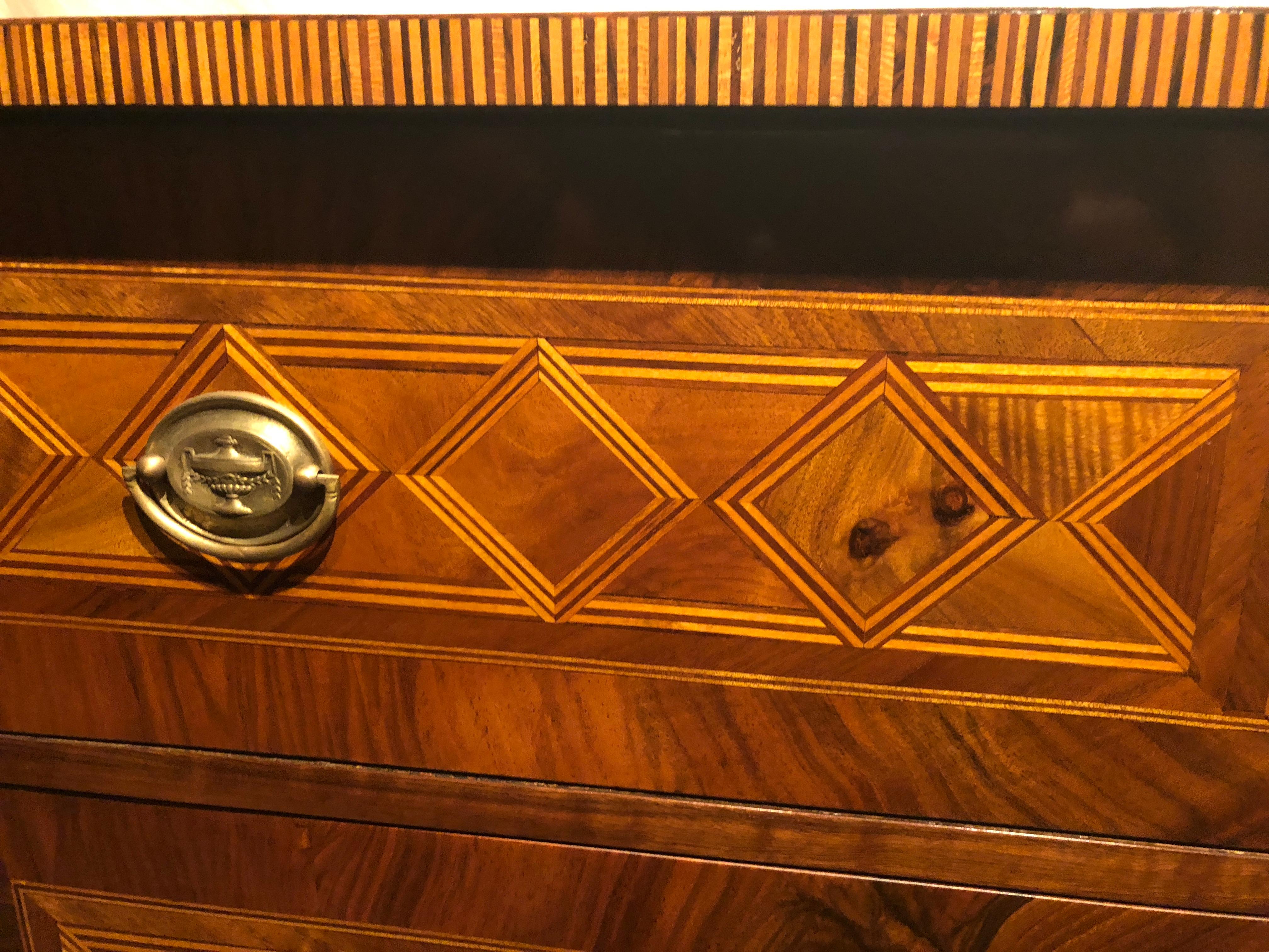 Stunning Louis XVI Chest of Drawers, South German, 1780, walnut veneer and walnut, plum and yew marquetry with geometric shapes on top, sides and front. Original brass fittings. The commode is in very good, refinished condition. French polished. 