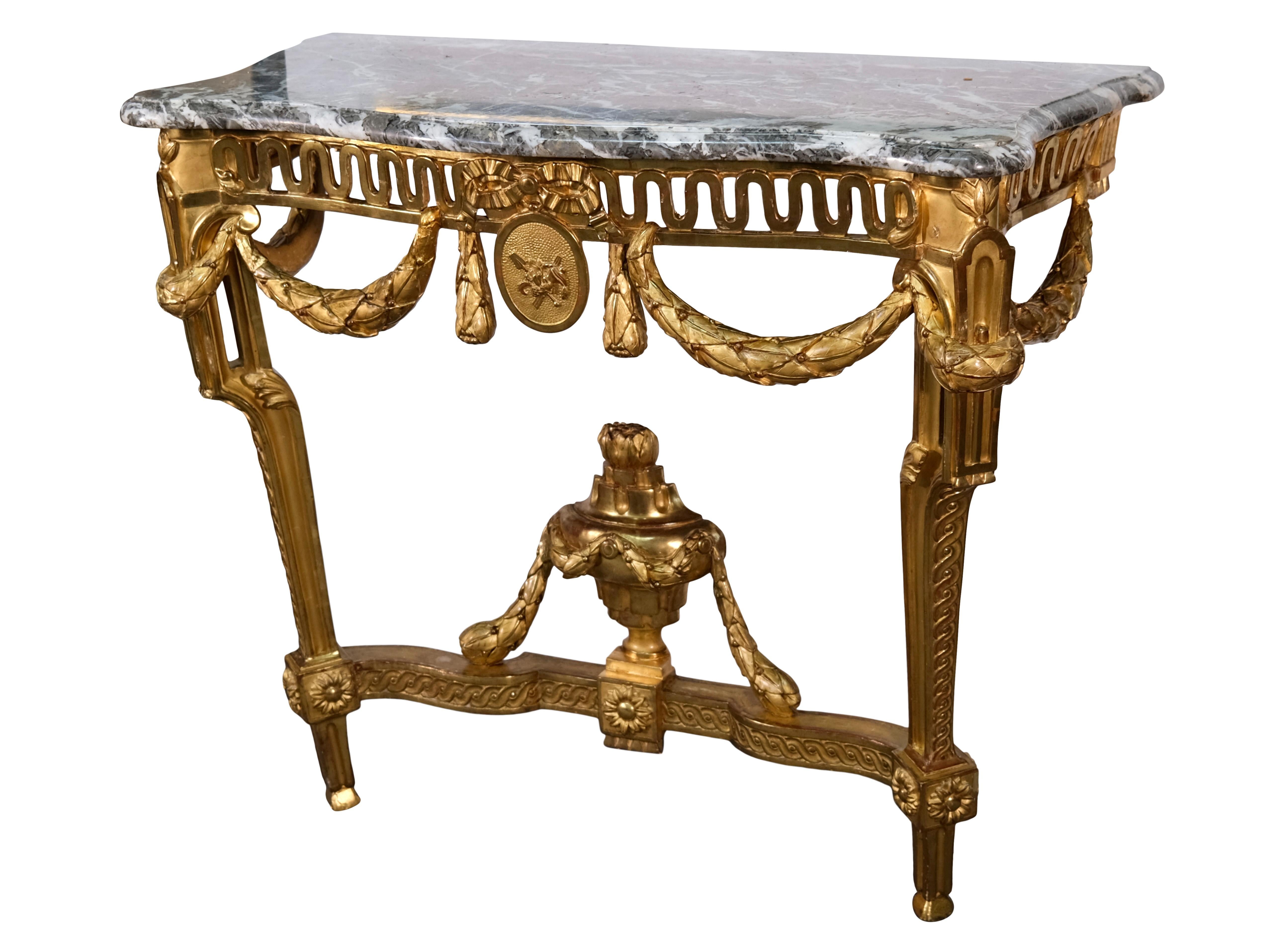 This exceptional Louis XVI ensemble from around 1780 comprises a finely carved console with its wall mirror – both richly gilded and superbly crafted, combining classical refinement with decorative splendor. 

The console stands on fluted legs with