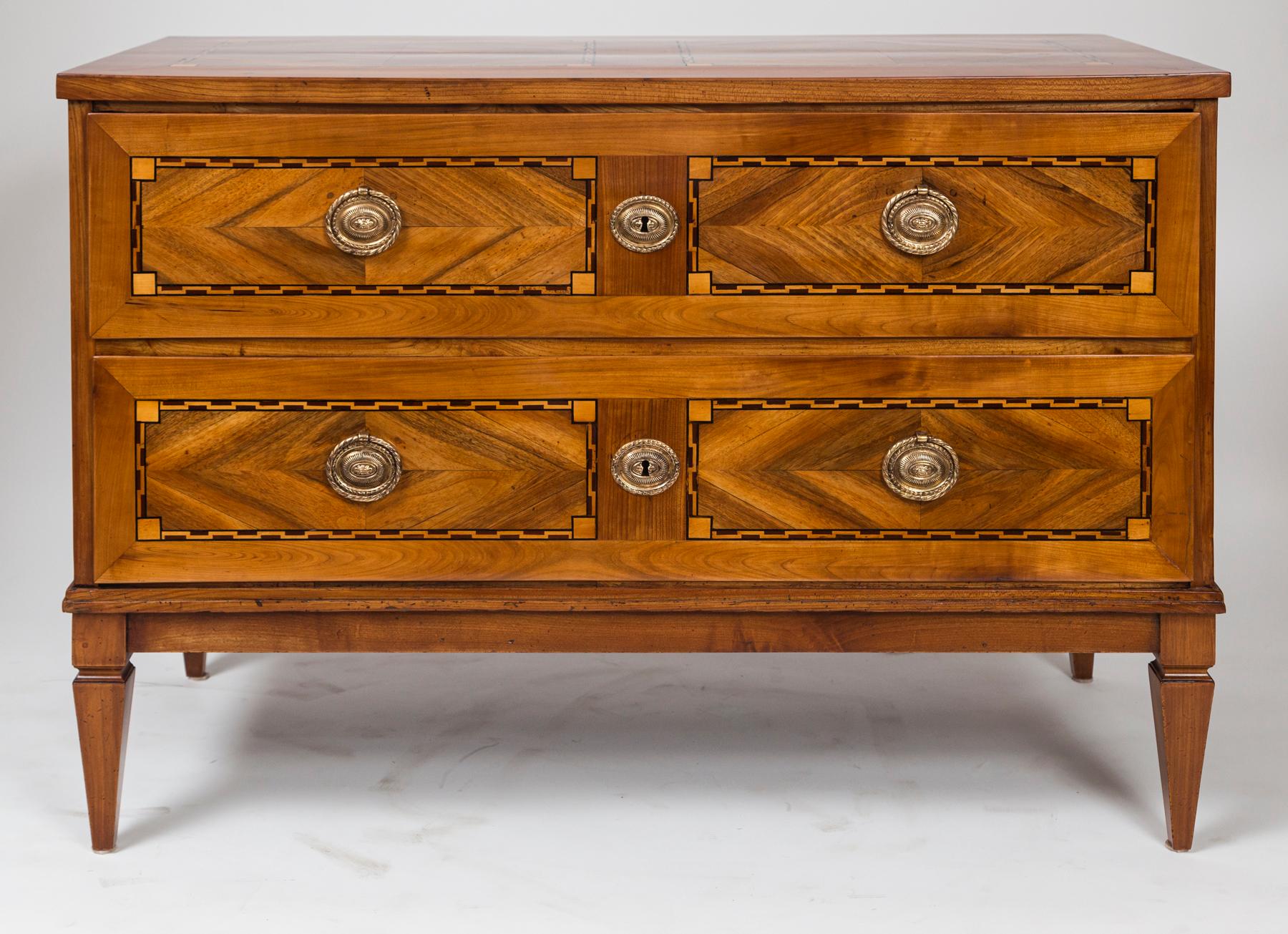 A handsome Neoclassical geometric panelled cherry and walnut chest comprised of two long drawers opening with round brass pulls and finishing on straight and tapered legs.

Condition: Excellent antique condition, original carcass in re-polished