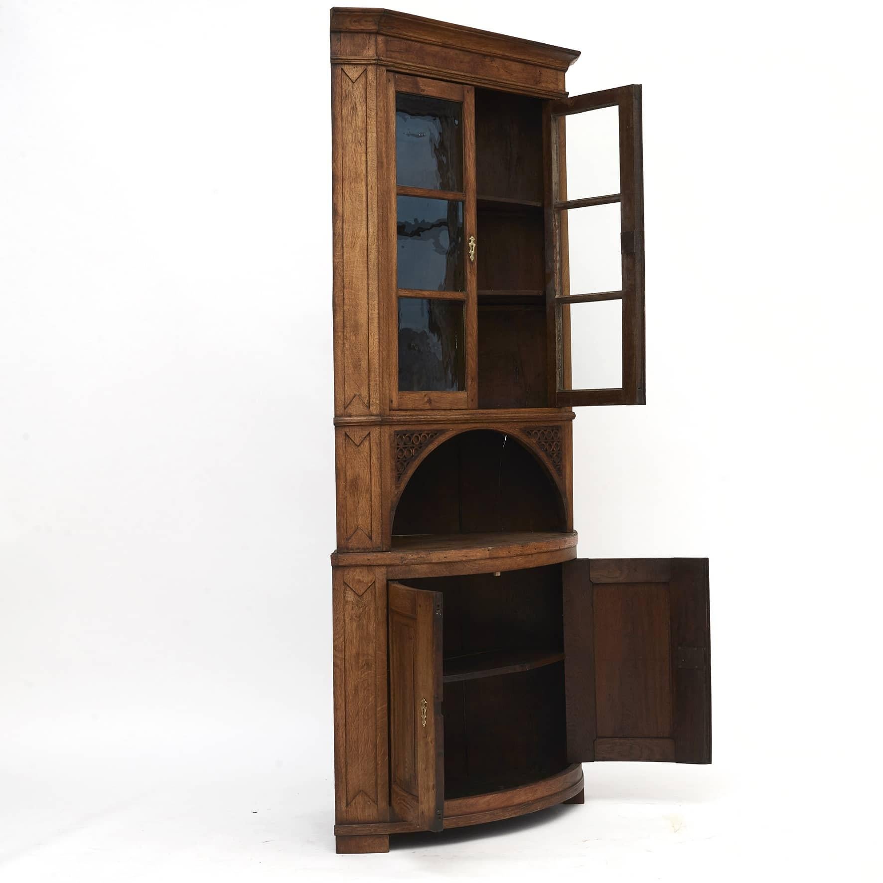 Louis XVI corner cabinet, made of oak in two parts.
Upper cabinet with a straight front and a pair of doors with bars and original glass in the fields.
Upper cabinet D: 57 cm, with profiled fillings.
Lower part D: 86 cm, pair of doors with curved