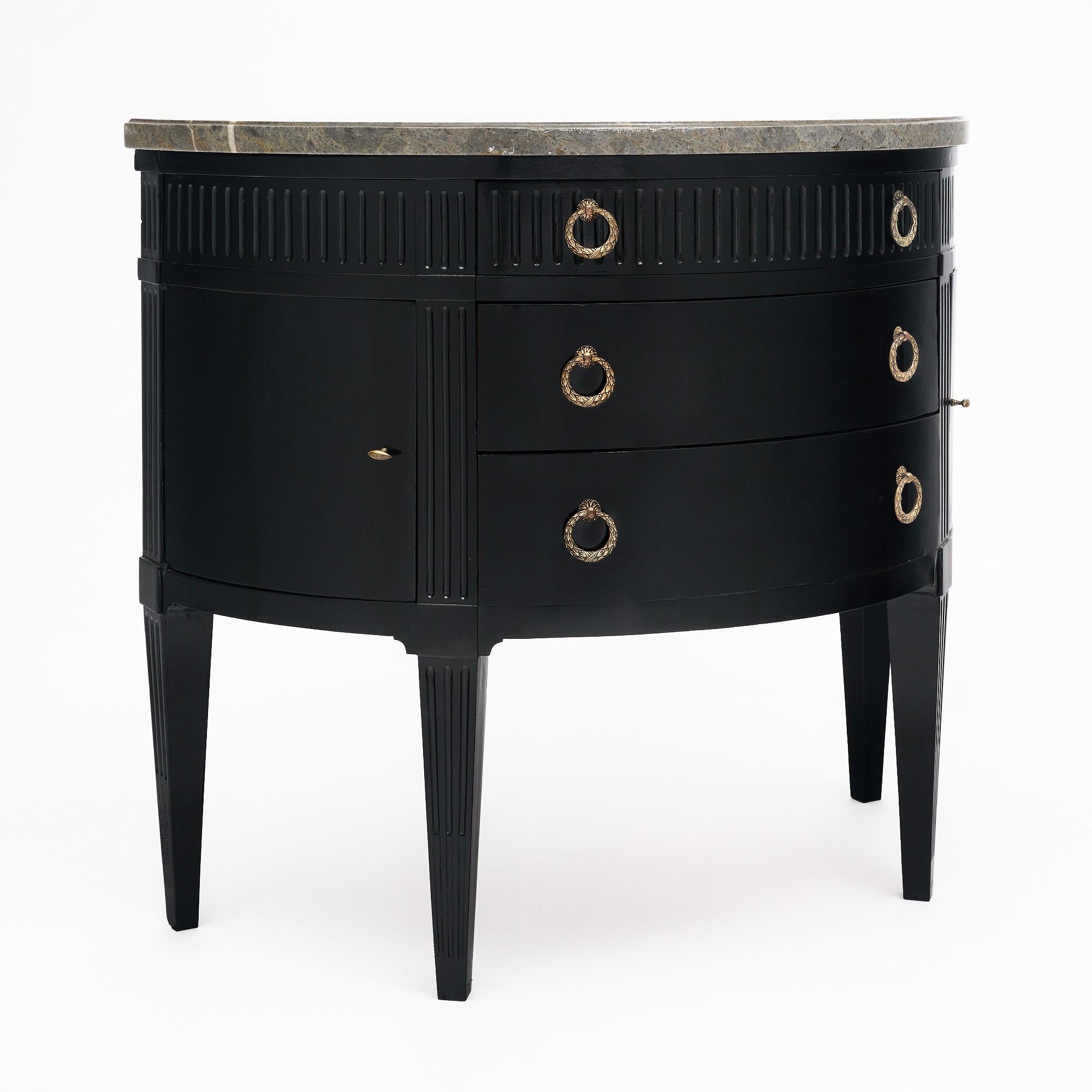 Commode française de style Louis XVI. Cette pièce est fabriquée en bois massif, principalement en acajou. La forme démilunie ajoute une qualité unique. Cette pièce a été finie avec un vernis français lustré et ébonisé de qualité muséale. Il y a