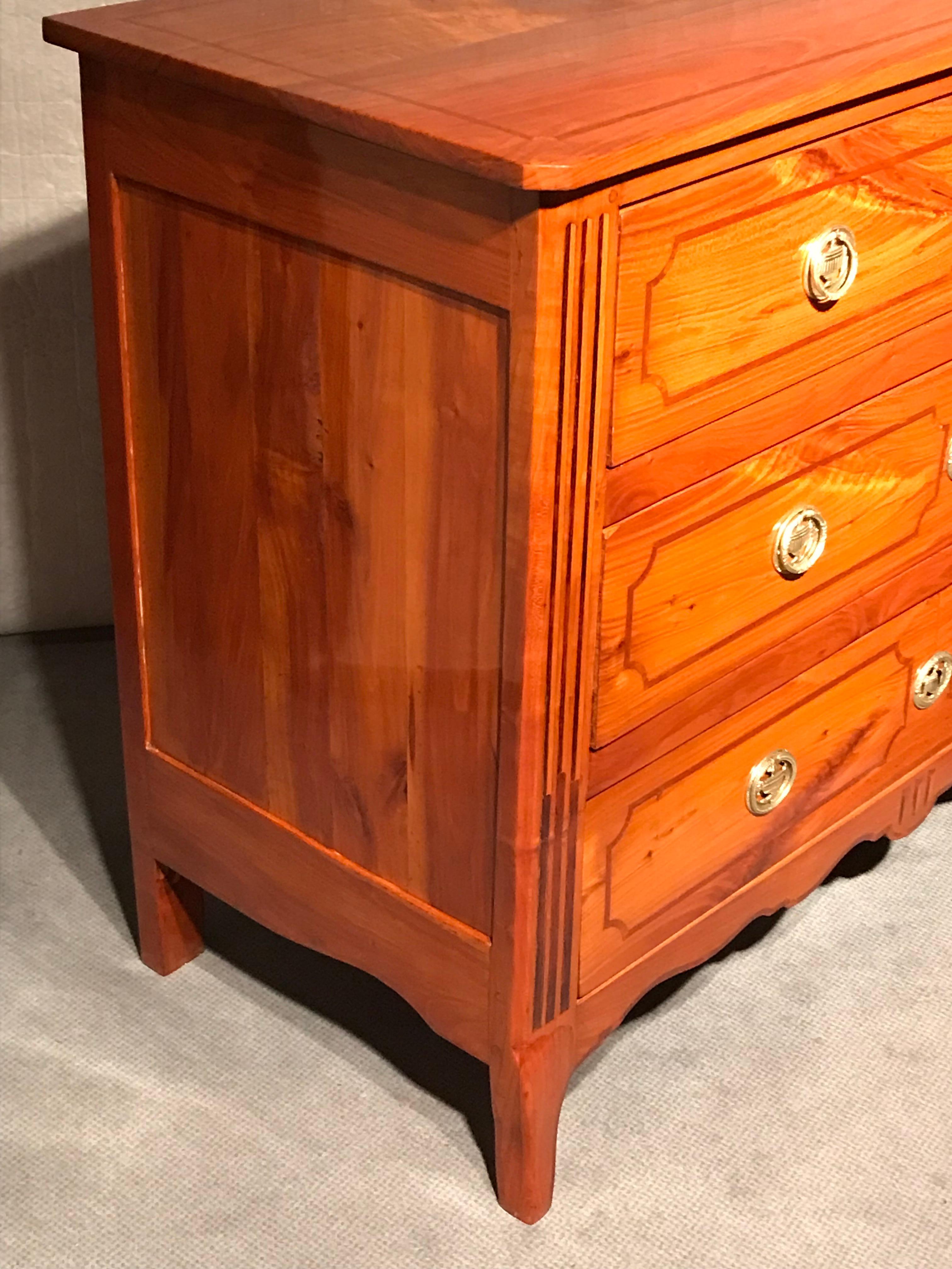 Questa cassettiera Luigi XVI, unica nel suo genere, risale al 1780 circa e proviene dalla Francia occidentale. Il mobile a tre cassetti ha un'impiallacciatura in ciliegio ed è decorato con intarsi in prugna sulla parte anteriore e superiore. I