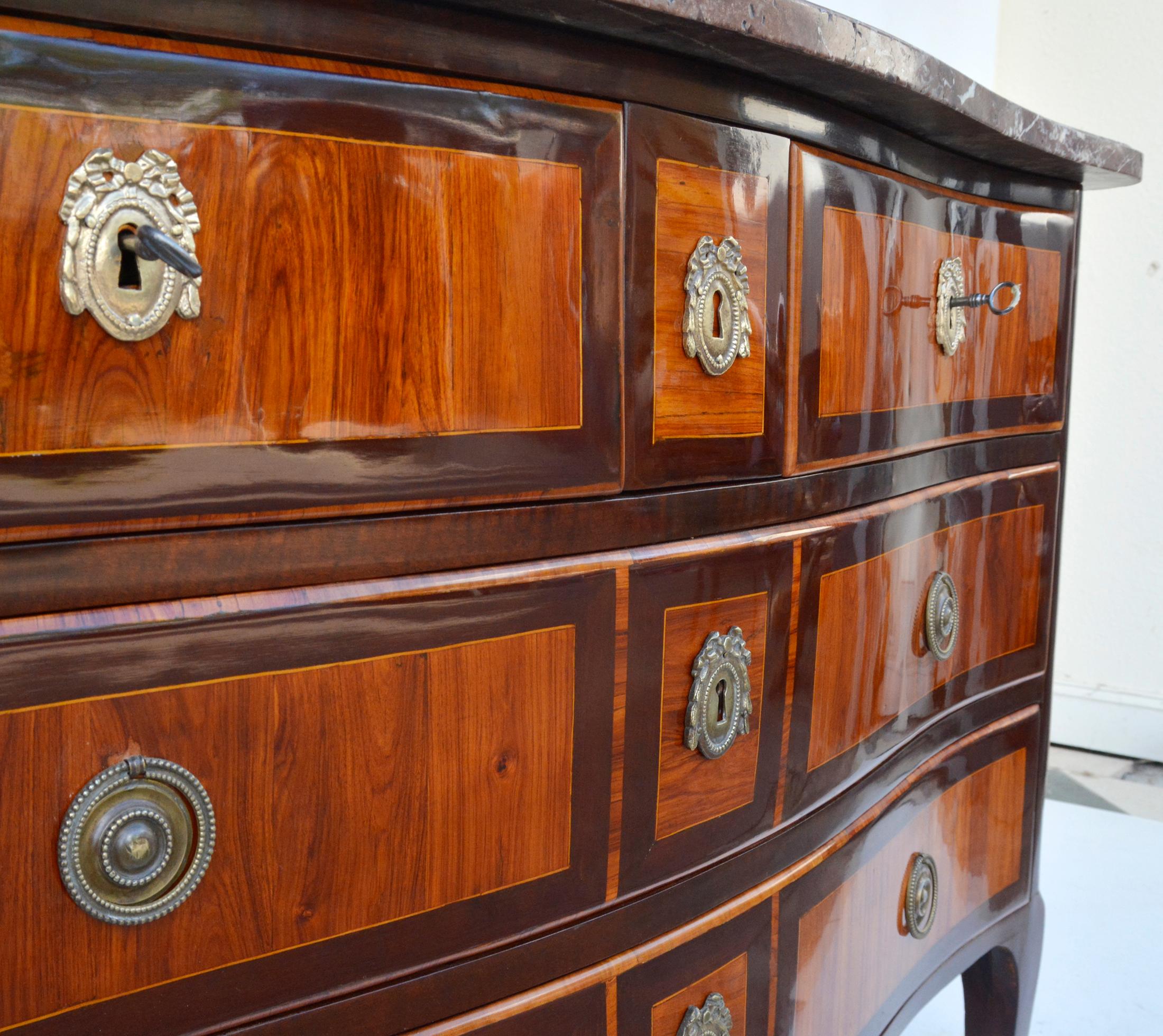 Louis XVI dresser in walnut and other precious woods, signed André-Antoine Lardin, Paris, 1780s.

Curved, conical rectangular legs. Cut-out frame, slightly forward curved body. The two lower drawers cover the full width of the body, the upper one