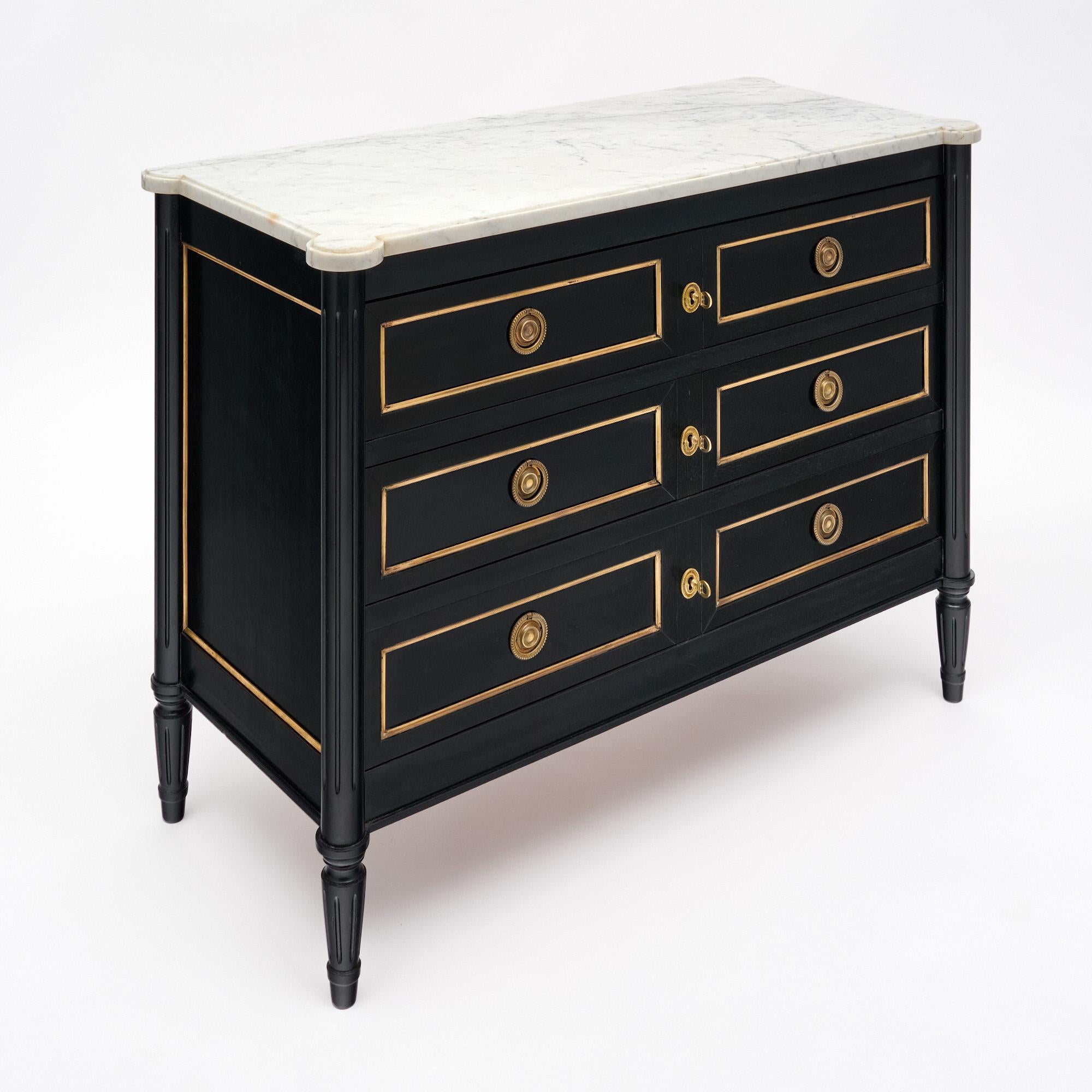 Chest of drawers in the Louis XVI style from France. This piece is made of solid wood construction, primarily mahogany. It has been ebonized and finished with a lustrous museum-quality French polish with gilt brass trim throughout. Three dovetailed