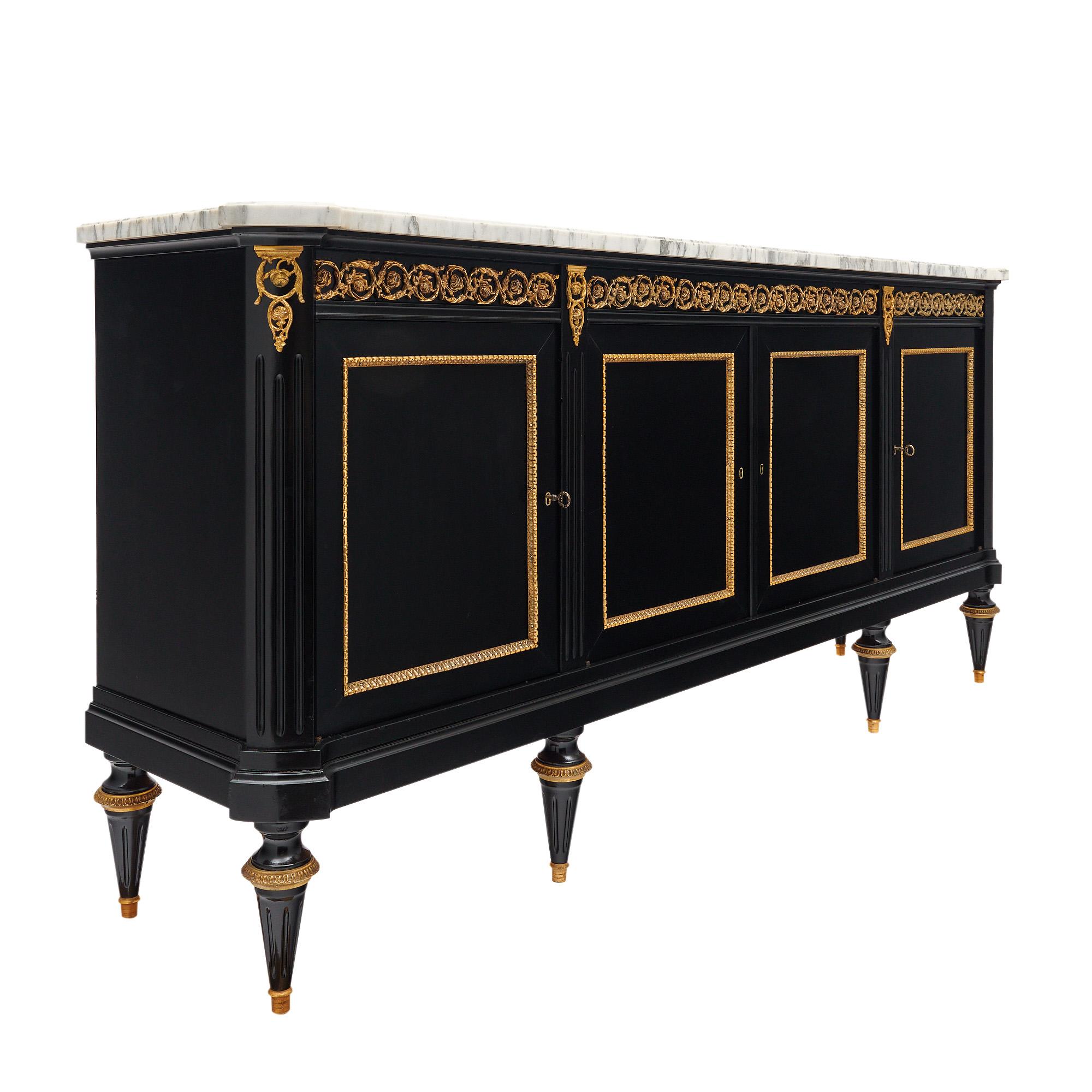 Buffet francese in stile Luigi XVI. Questo pezzo è realizzato in mogano ebanizzato e rifinito con una lucentezza francese di qualità museale. Ci sono quattro porte che si aprono su scaffali interni. Nella traversa il buffet è ornato da un fregio in