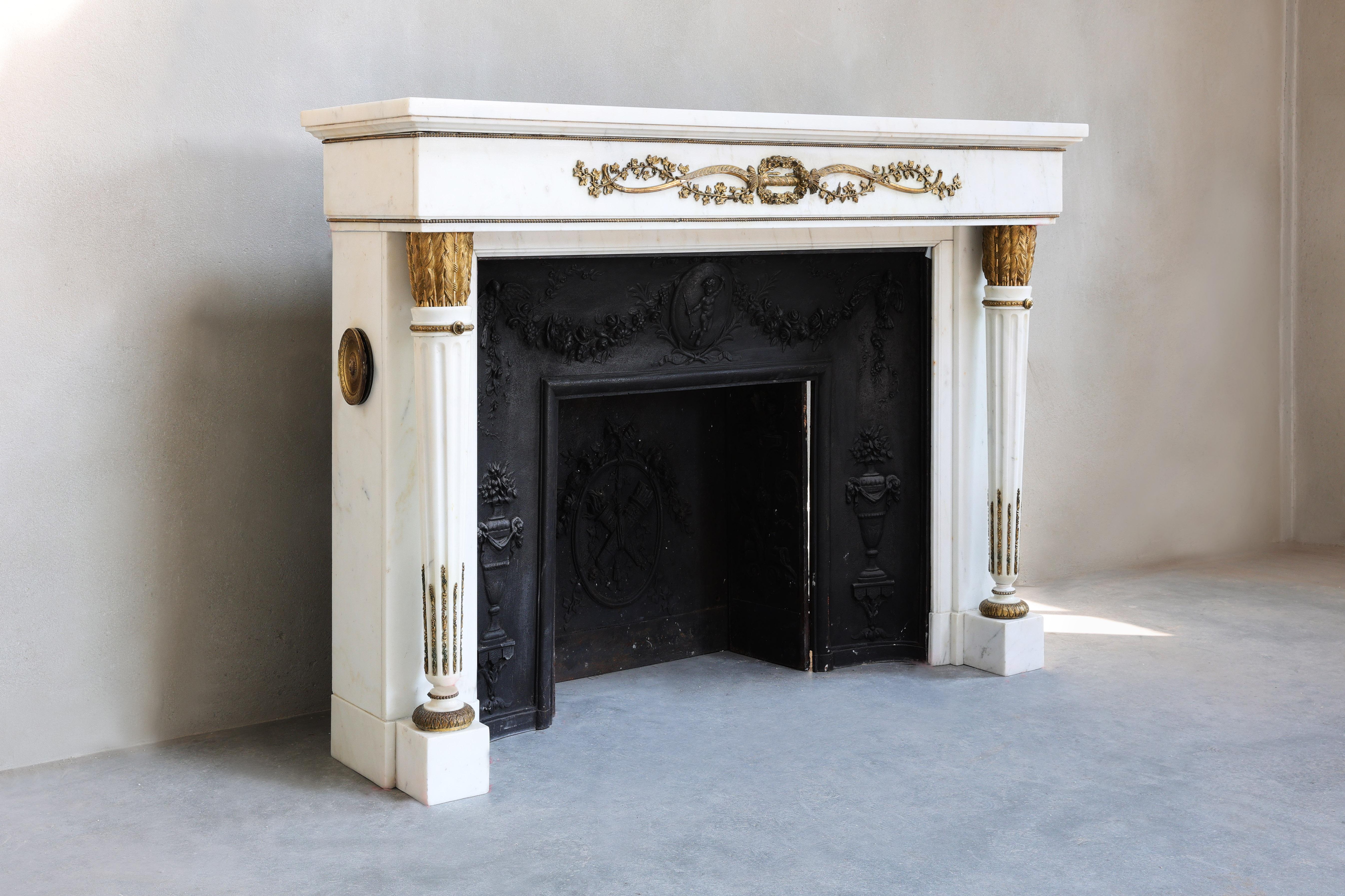 Important early 19th Century antique fireplace in Statuary Carrara marble with quiver-shaped columns and gilt bronze ornaments. 
Its original provenance is Chateau de la Gesse - Boulogne sur Gesse.
Between 1820-1840 the fireplace has been designed