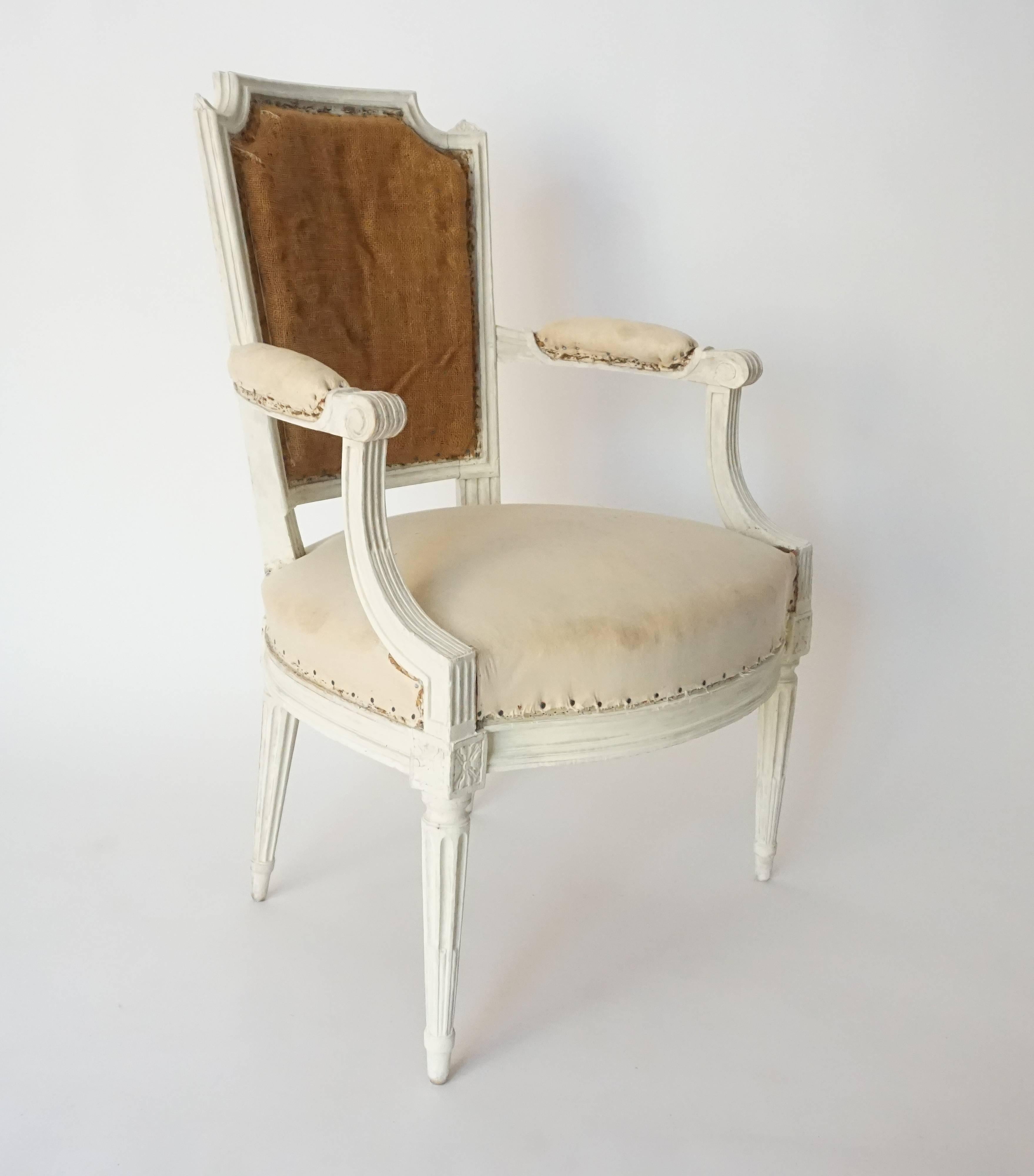 French, circa 1780 Louis XVI fauteuil or armchair having carved fruitwood frame in original paint with 