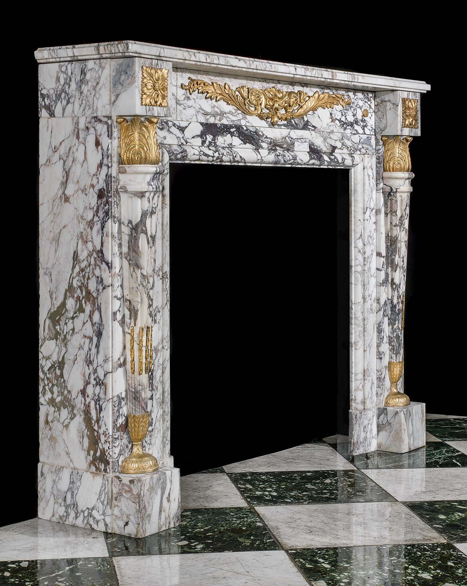 A highly decorative, small but chic Louis XVI fireplace mantel carved in Breche Violette Marble with applied ormolu mounts in the manner of Pierre Gouthiere (1732-1813) who was appointed ciseliste, doreur, bronze chaser and gilder by Aux Menus