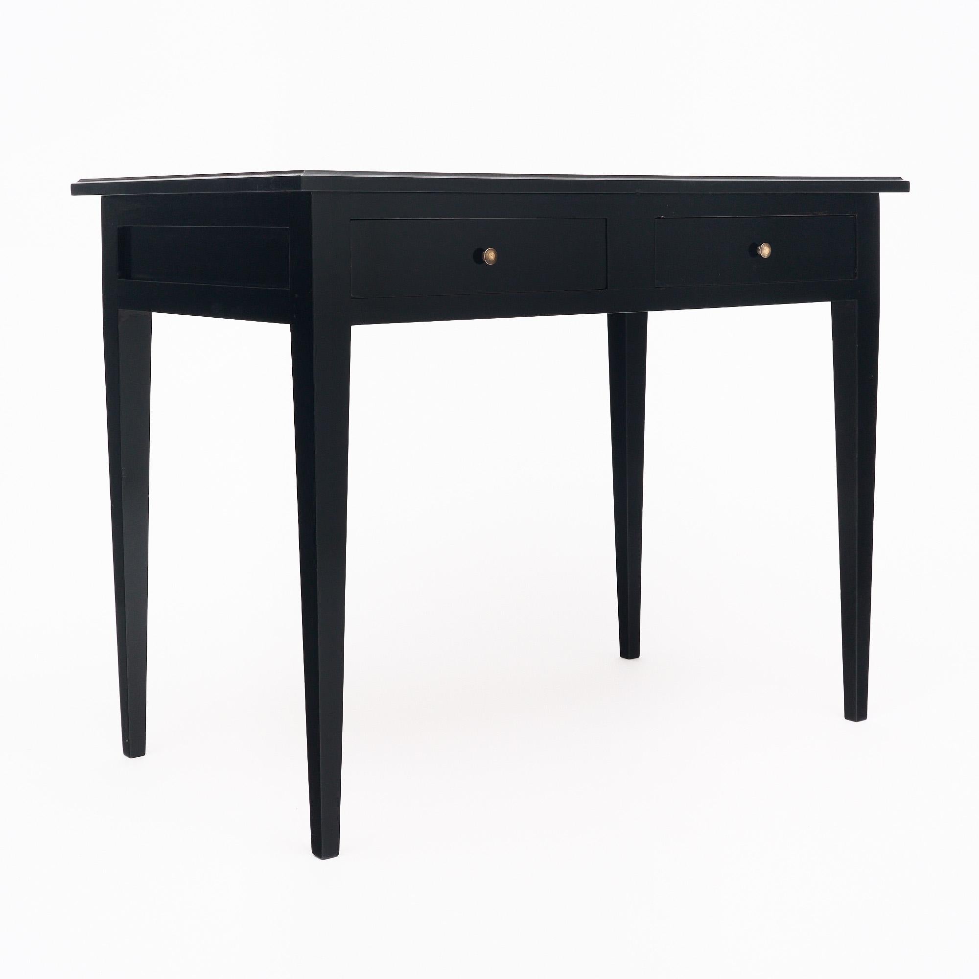 Writing desk from France in the Louis XVI style. This piece is made of solid wood construction, primarily mahogany. It has been finished with a lustrous ebonized French polish finish of museum-quality. The top features a leather covered writing