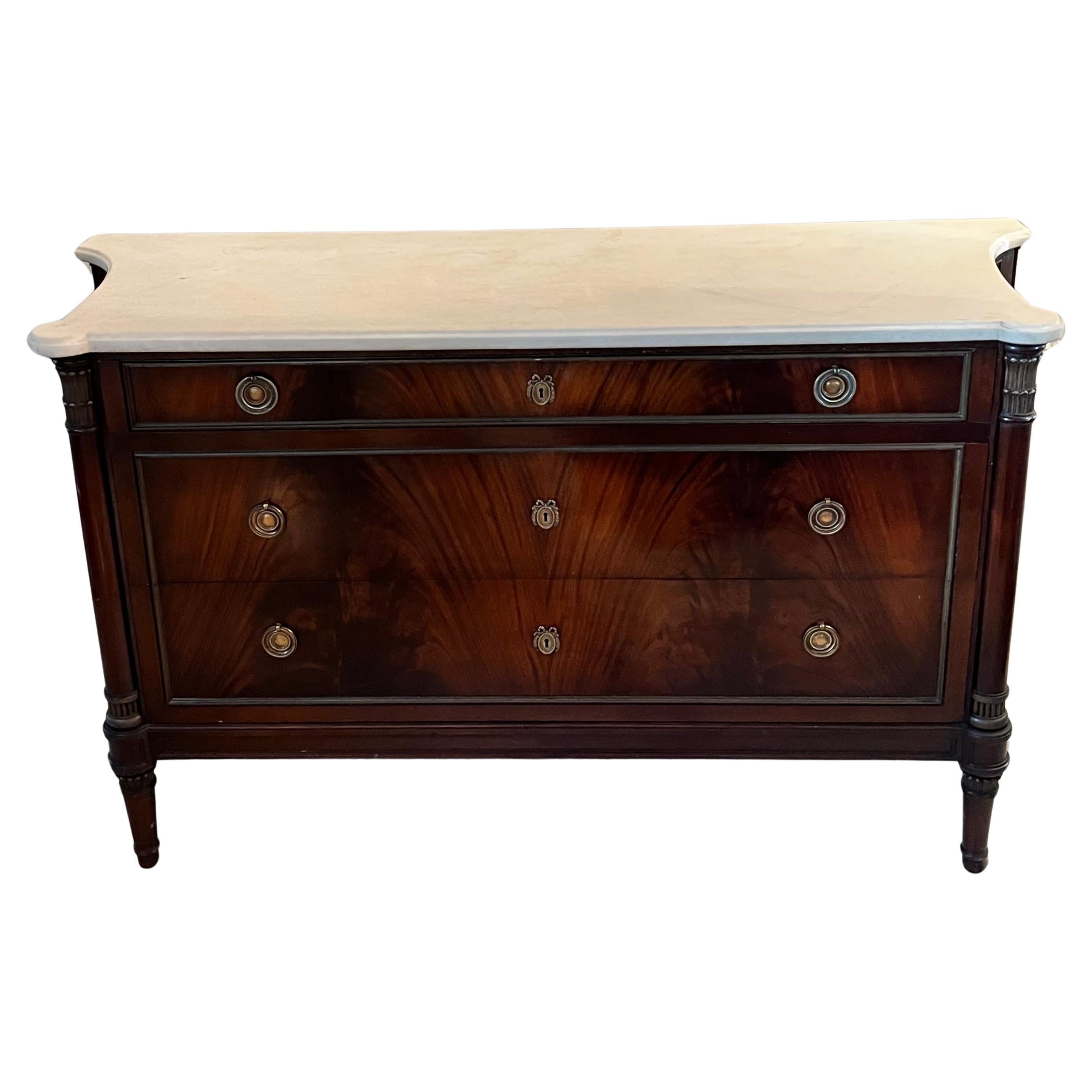 A Stunning Early 20th Century French Louis XVI Commode or Chest of drawers.  The wood is a gorgeous Mahogany with a statuary marble top.  The three drawers are deep and roomy.  The top drawer has many divisions and a place for small contents, and