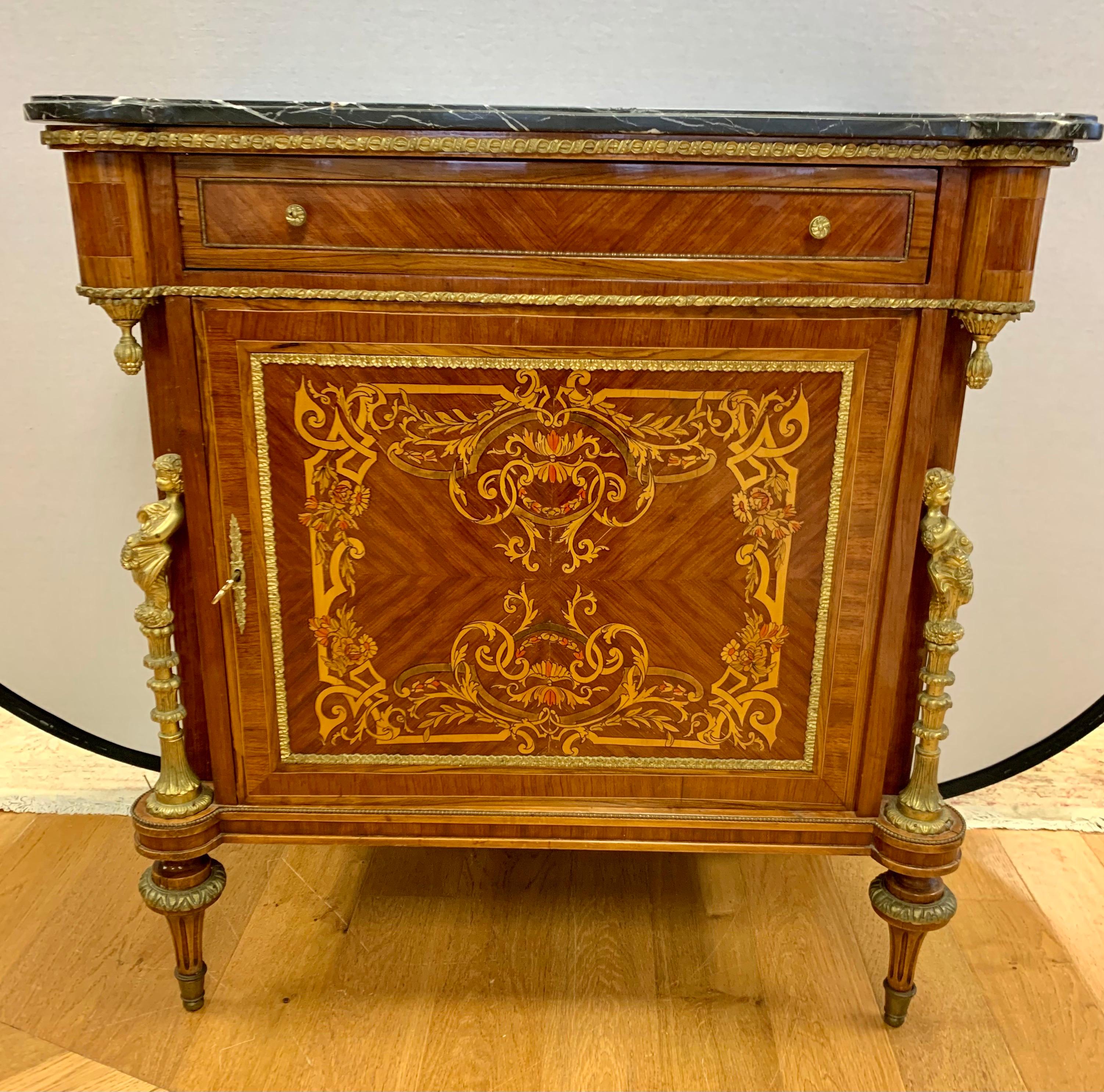 Magnificent 19th century Louis XVI style marble top chest that features heavy veining in the marble,  bronze ormolu figural mounts and marquetry at front and sides. There is a repair at the left lower portion of the marble that does not diminish the