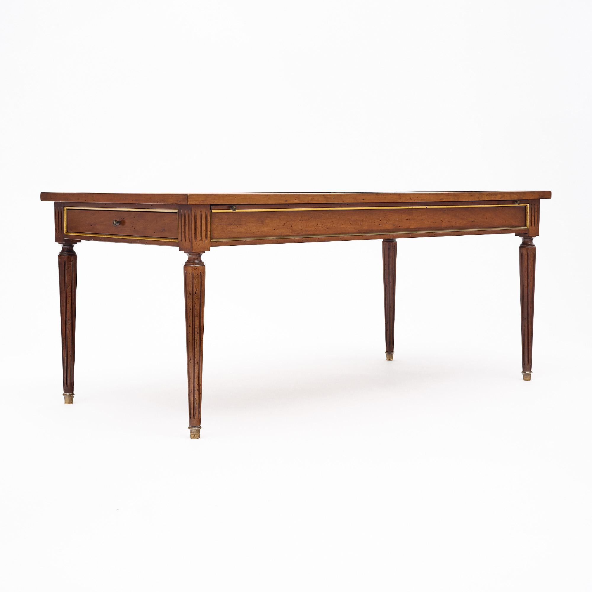 Table basse de France en bois massif, principalement en noyer. Les pieds sont longs et effilés dans le style Louis XVI classique. Il a été recouvert d'un vernis français lustré de qualité muséale. Le plateau a un effet parqueté et les feuilles se