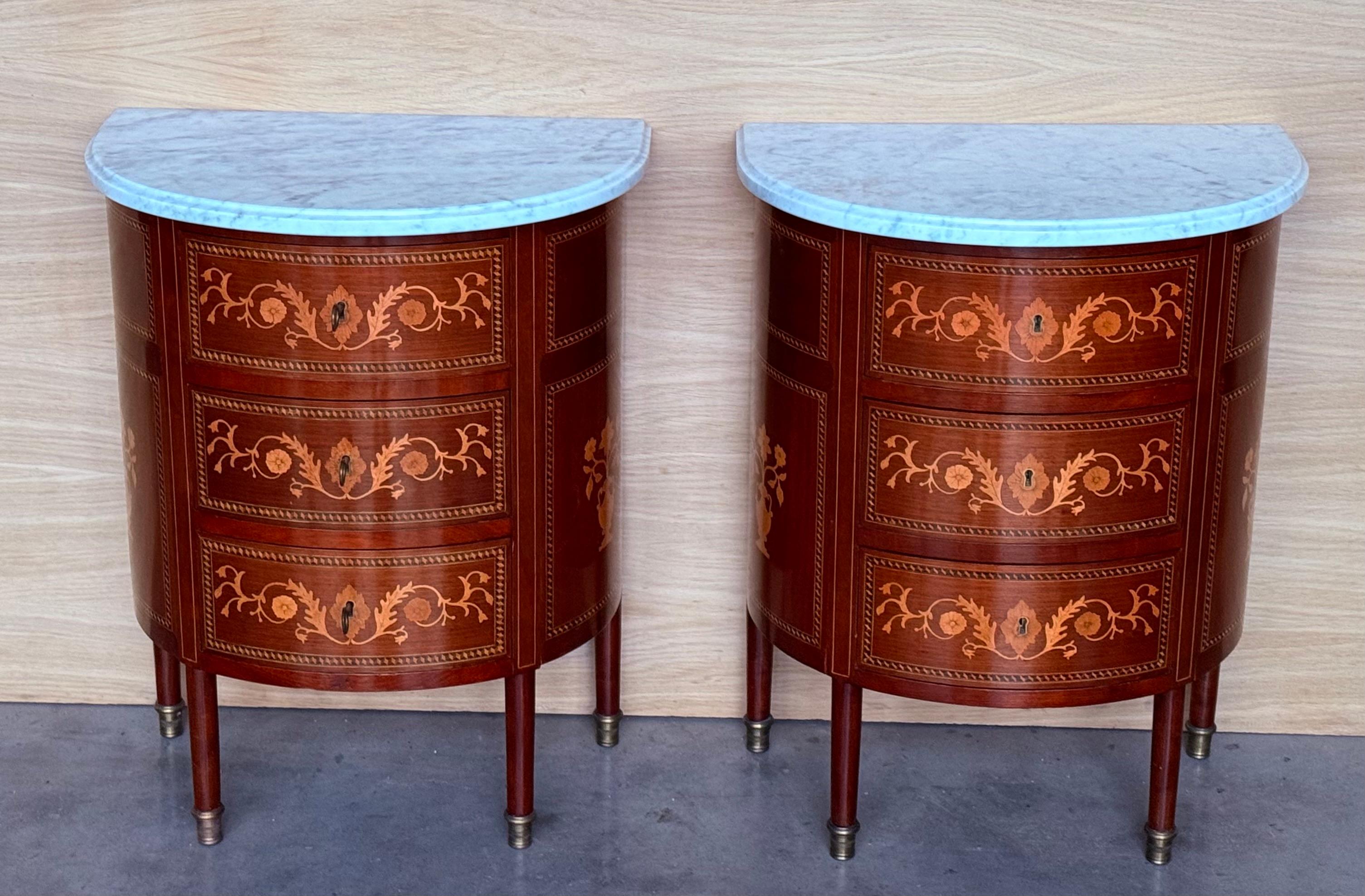 A pair of Louis XVI style French demilune marble top side tables, or nightstands made of solid mahogany, each with a dovetailed drawer and slender turned tapered legs. One stand has a cabinet door with a brass knob and one has an open niche front.