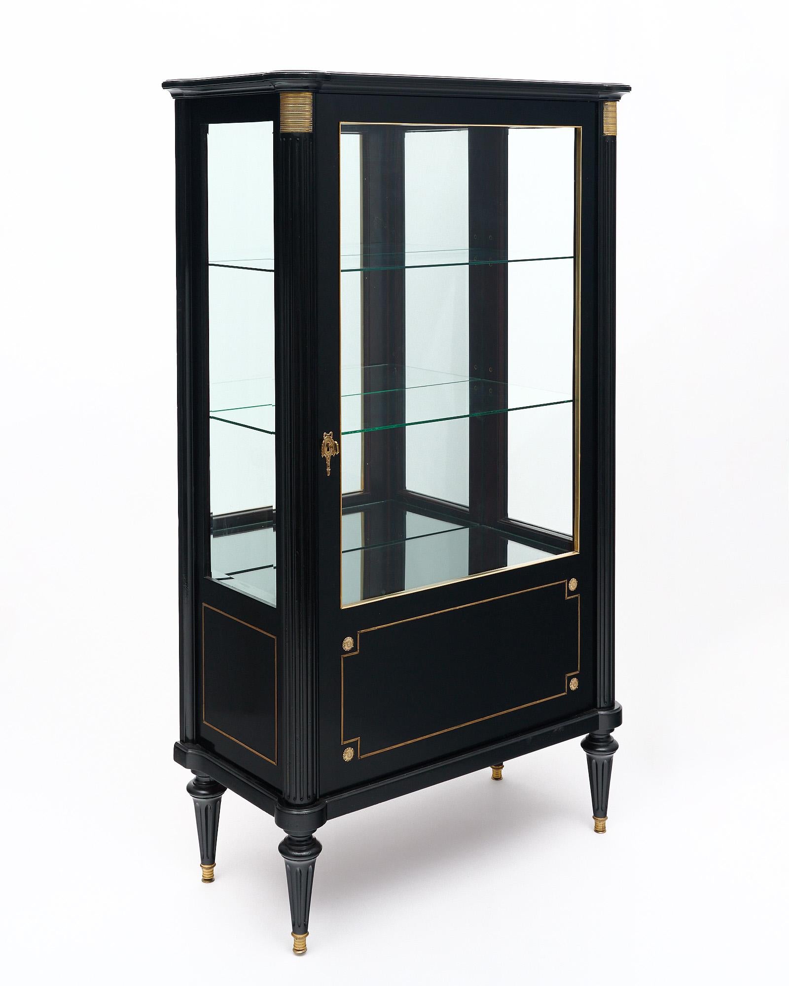 Libreria o Vitrina francese in stile Luigi XVI. Questo pezzo è realizzato in legno massiccio, principalmente mogano. La libreria è stata ebanizzata e rifinita con un lucido francese di qualità museale. Sono presenti i classici dettagli curvi agli