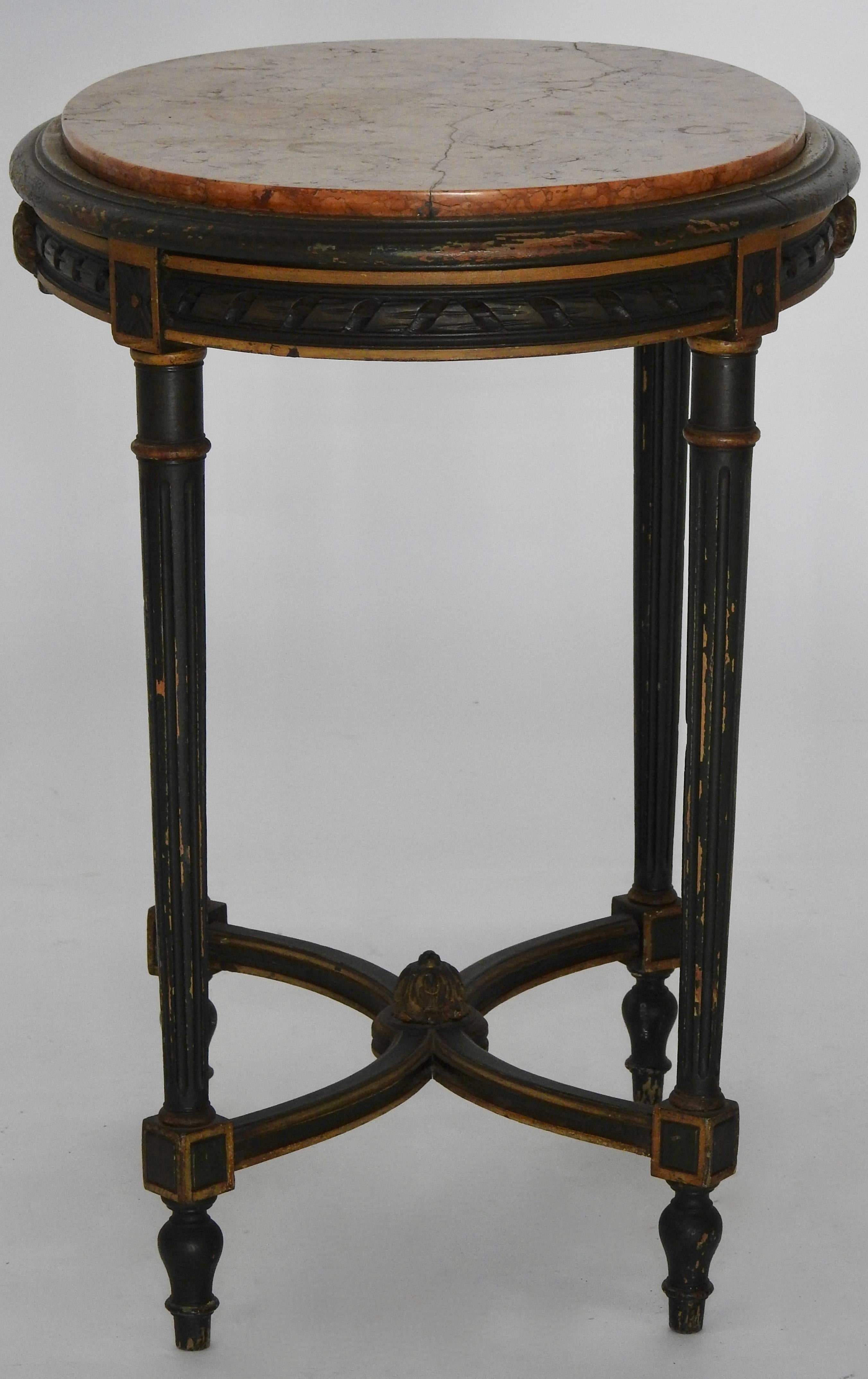This table is in a gorgeous dark green paint with gilding detailing. The marble is of warm red tones. The marble has had a repair done. Table stands on four round tapered legs with curved stretchers. Decorated with finials and carving details.