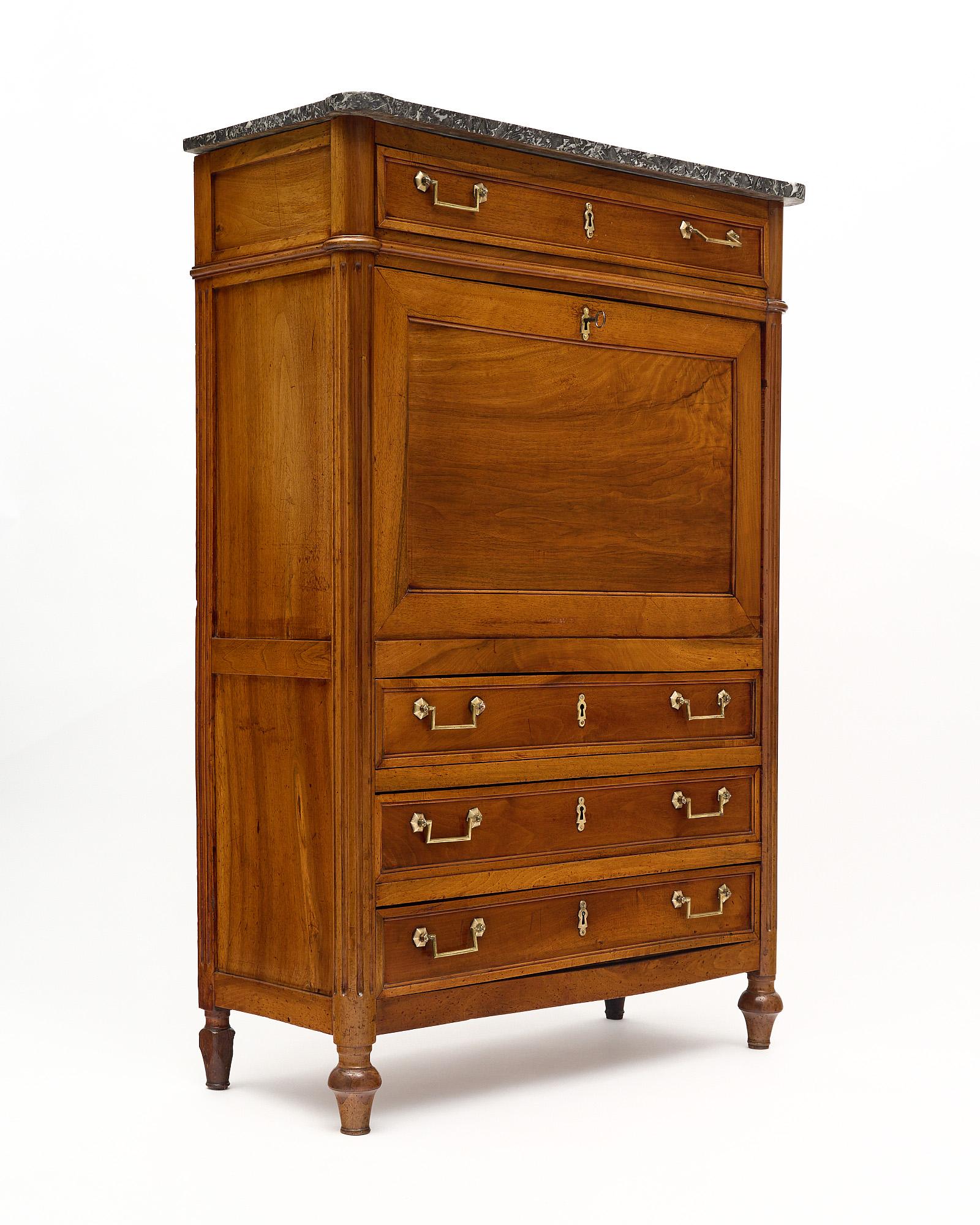 Secretary, drop front desk, from France in the Louis XVI style. This cabinet is made of blond walnut and has been finished in a lustrous museum quality French polish. There are four dovetailed drawers all featuring gilt brass hardware. The drop
