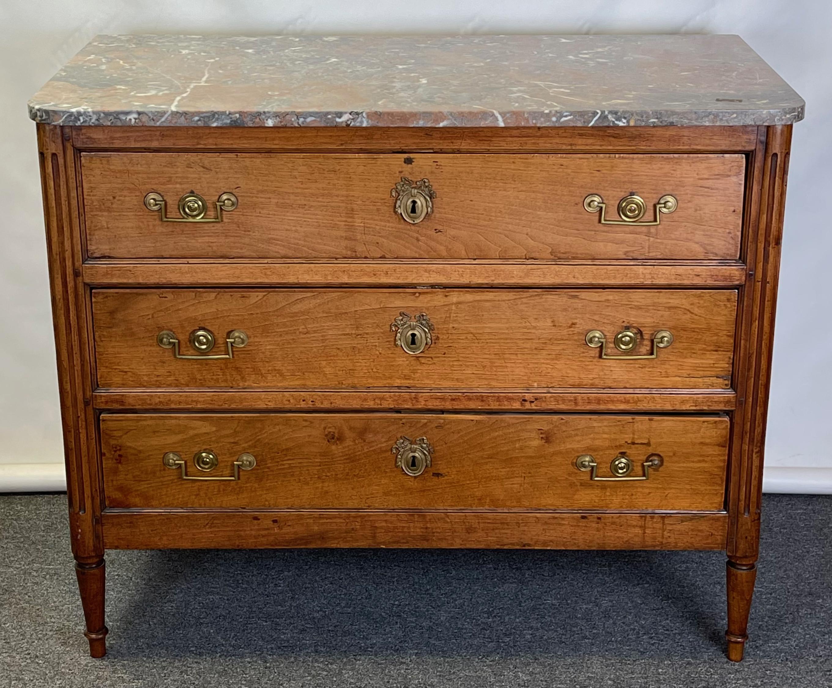 A late 18th C. French three drawer fruitwood commode with old, possibly original marble top.