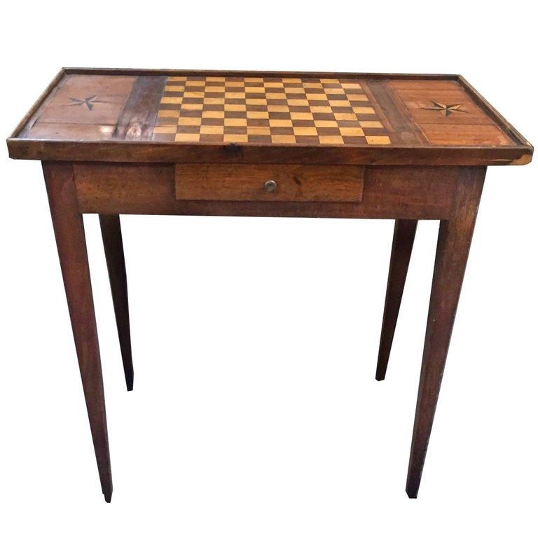 This distinguished Louis XVI gaming table features a parquetry top for playing chess as well as two lovely five pointed star inlays. One drawer for gaming or other storage.
