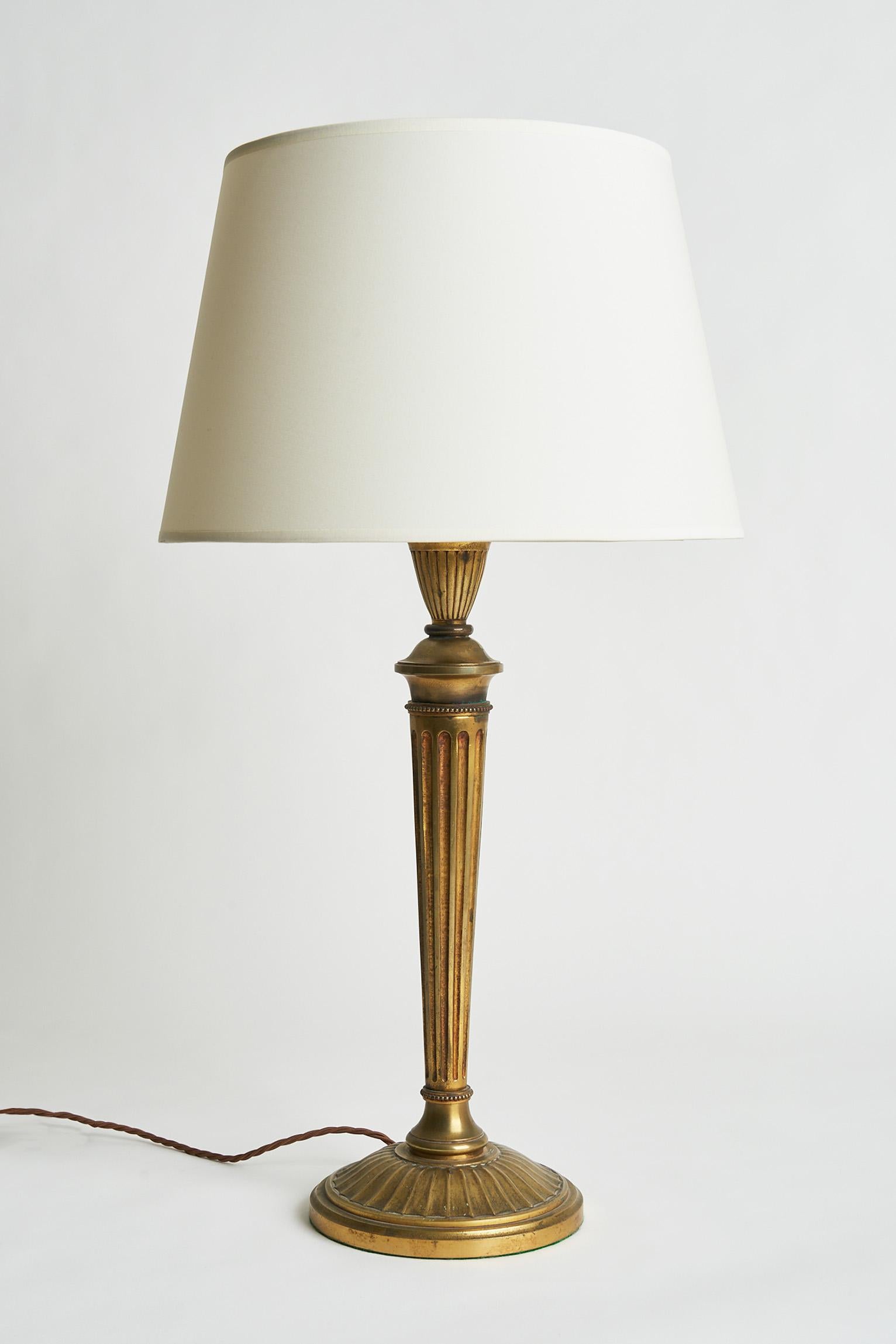 A large Louis XVI style gilded bronze table lamp.
France, Circa 1900.
Measures: With the shade: 75 cm high by 40 cm diameter.
Lamp base only: 56 cm high by 20 cm diameter.