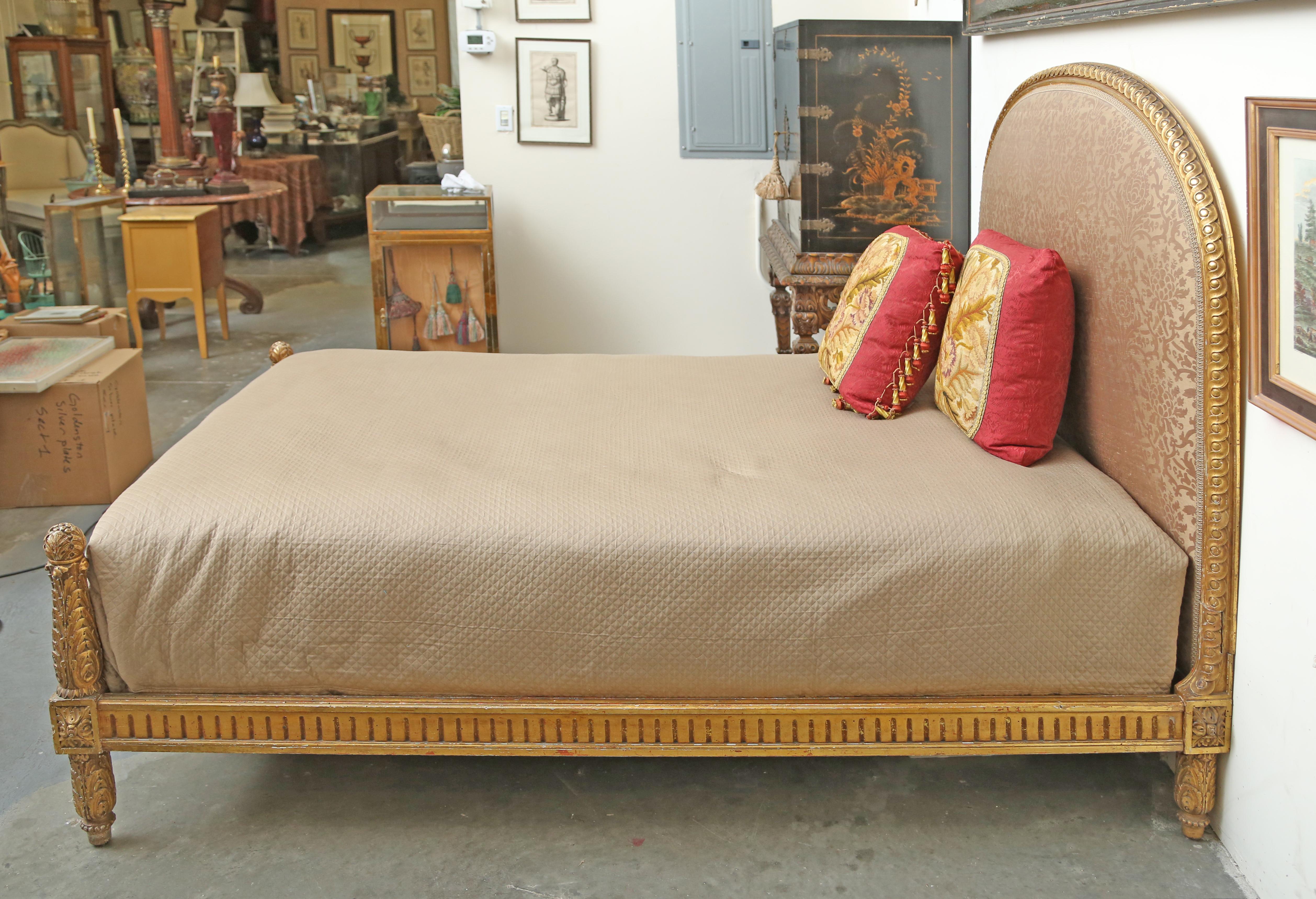 Louis XVI style gilt full size bed. The bed consists of a headboard, footboard, pair of side rails, stretchers and bed bolts. The headboard is upholstered in a Fortuny like silk. The very sturdy bed has a headboard with beautiful deep guilloche