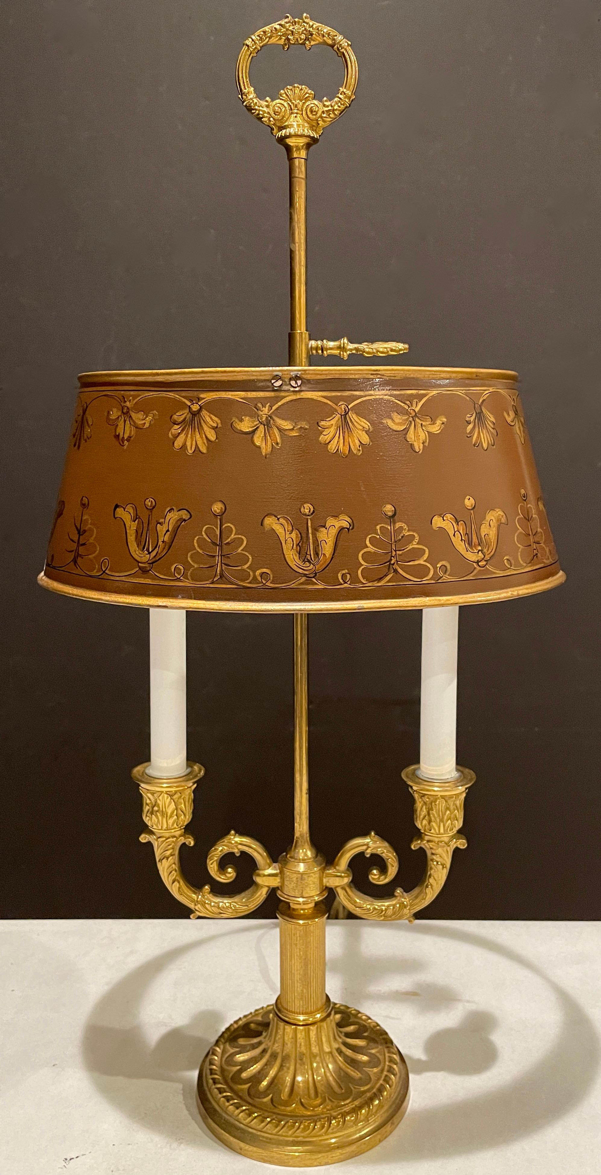 Vieille lampe bouillotte à 2 lumières en bronze doré et tole. Base ronde en bronze et abat-jour ovale réglable en tole dorée et peinte, avec deux bras de bougies et un embout en forme de couronne.