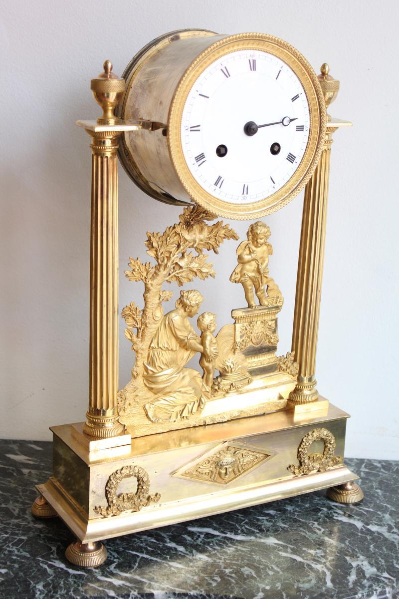 Louis XVI gilt bronze portico clock with enamelled dial. 
An offering to Love scene on the bas-relief.
Good condition
Dimensions: Height 38,5cm, Width 28cm, Depth 11cm