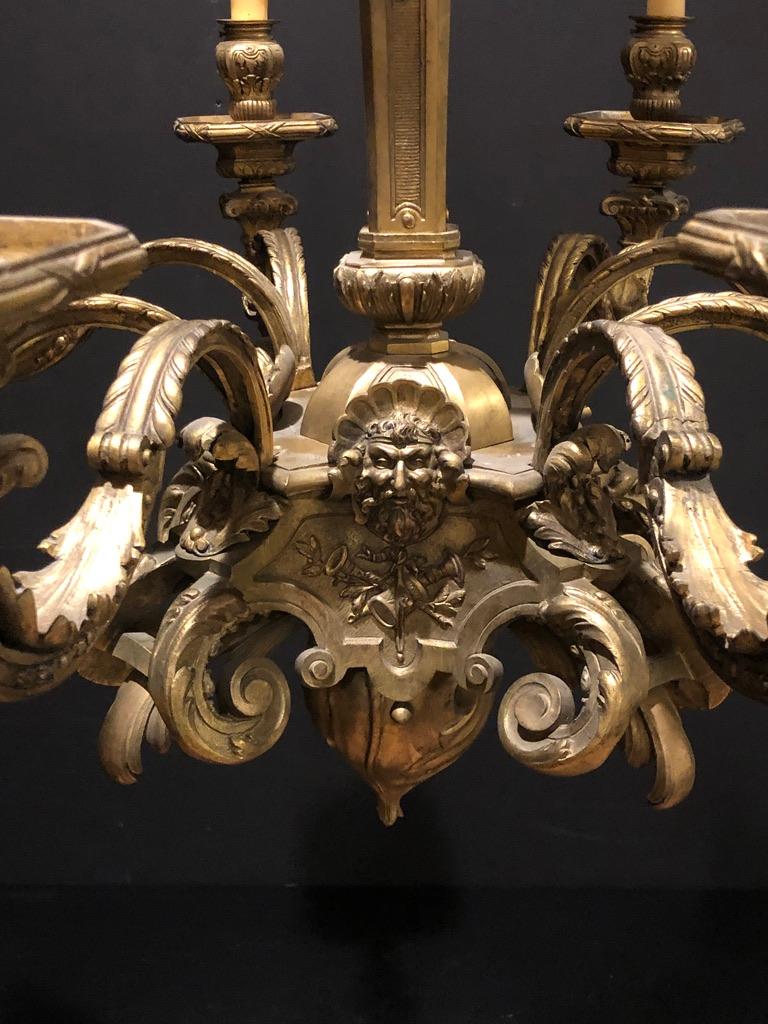 Antique Louis XVI gilt bronze eight-light chandelier. Adorned with figural masks, musical instruments and foliate scrolls. Fine quality detail.
Measures: 31