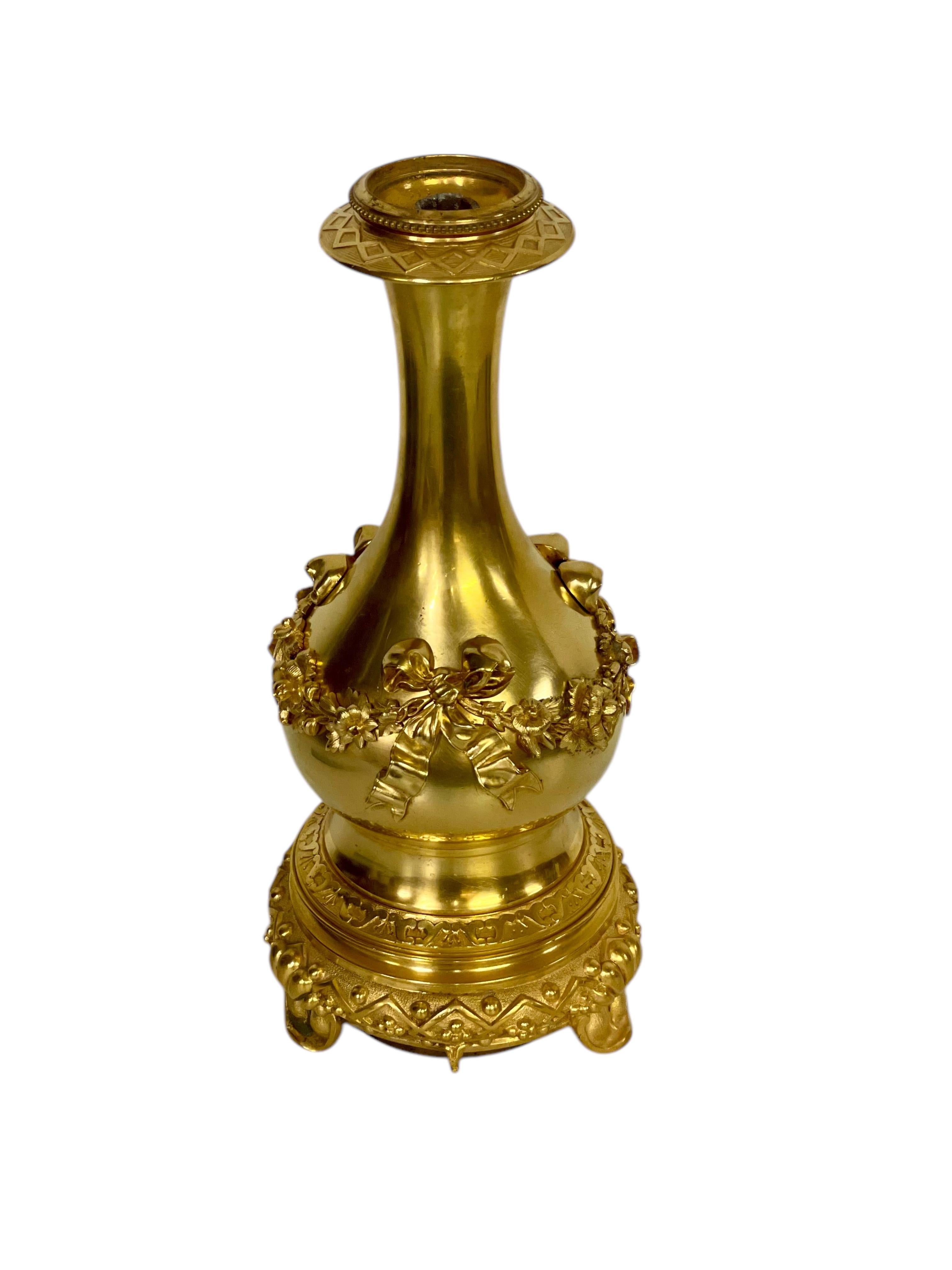 Hermoso ejemplo del diseño neoclásico francés, esta base de lámpara de bronce dorado (ormolu) se creó originalmente como lámpara de aceite durante el siglo XIX. El elegante cuerpo en forma de balaustre está ricamente adornado con guirnaldas florales