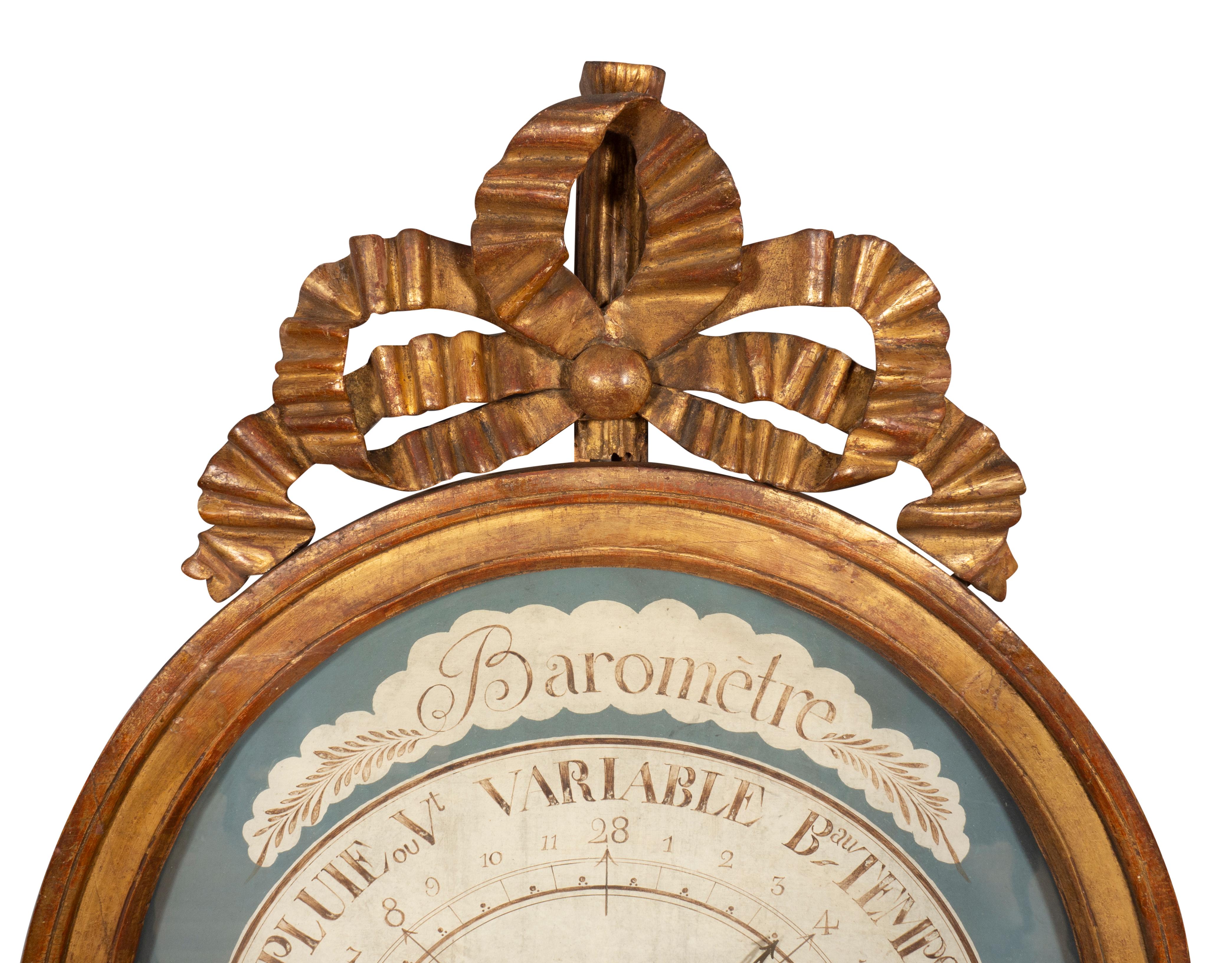 Oval mit Bandschleife über einem ovalen Barometer mit Glasfront und grisaille bemalter Tafel mit Directionals aus Metall. Beschriftet Selon Torricelli.