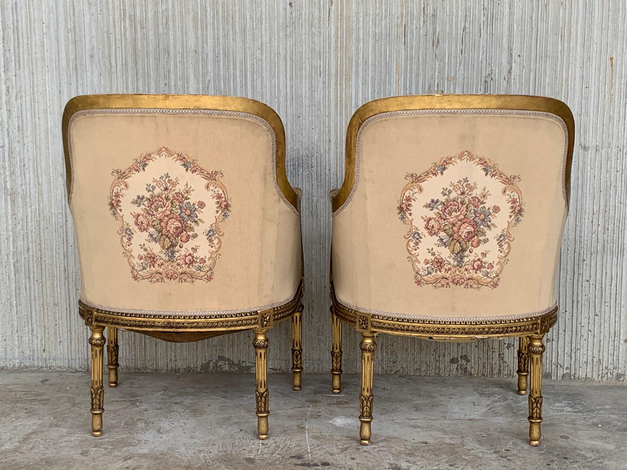 A striking pair of French 19th century Louis XVI giltwood bergères. Each armchair is raised by circular tapered fluted legs below fine block rosettes. Extending along the frieze are impressive and wonderfully carved interlocking patterns centering a