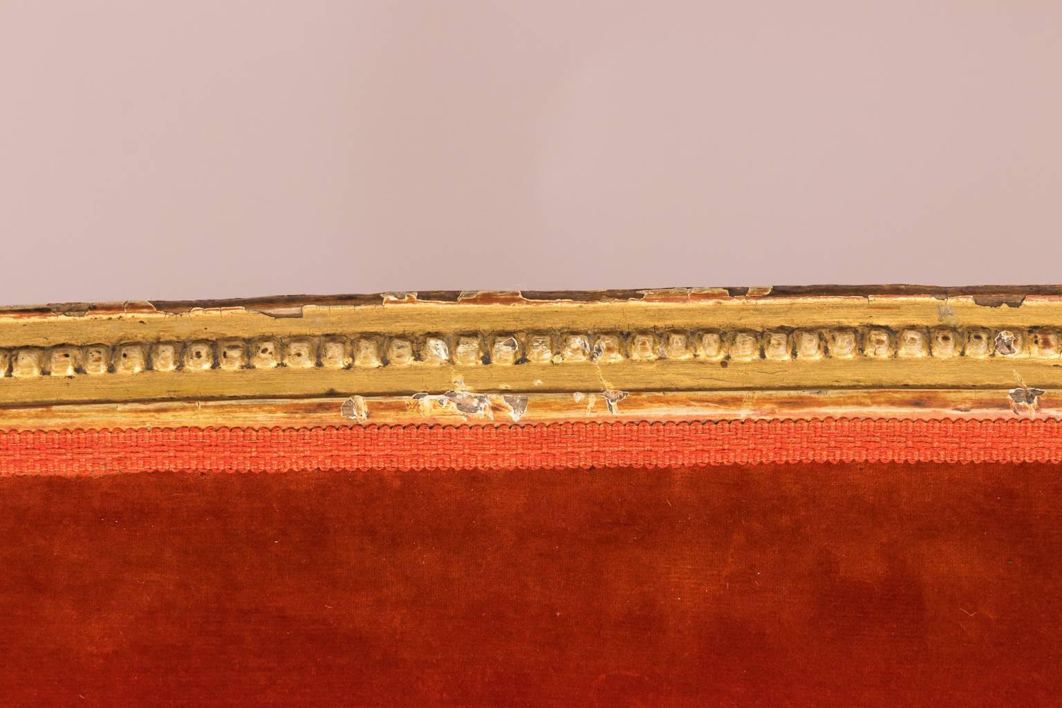 French Louis XVI giltwood sofa with rounded back and tufted tangerine velvet upholstery, circa 1780.