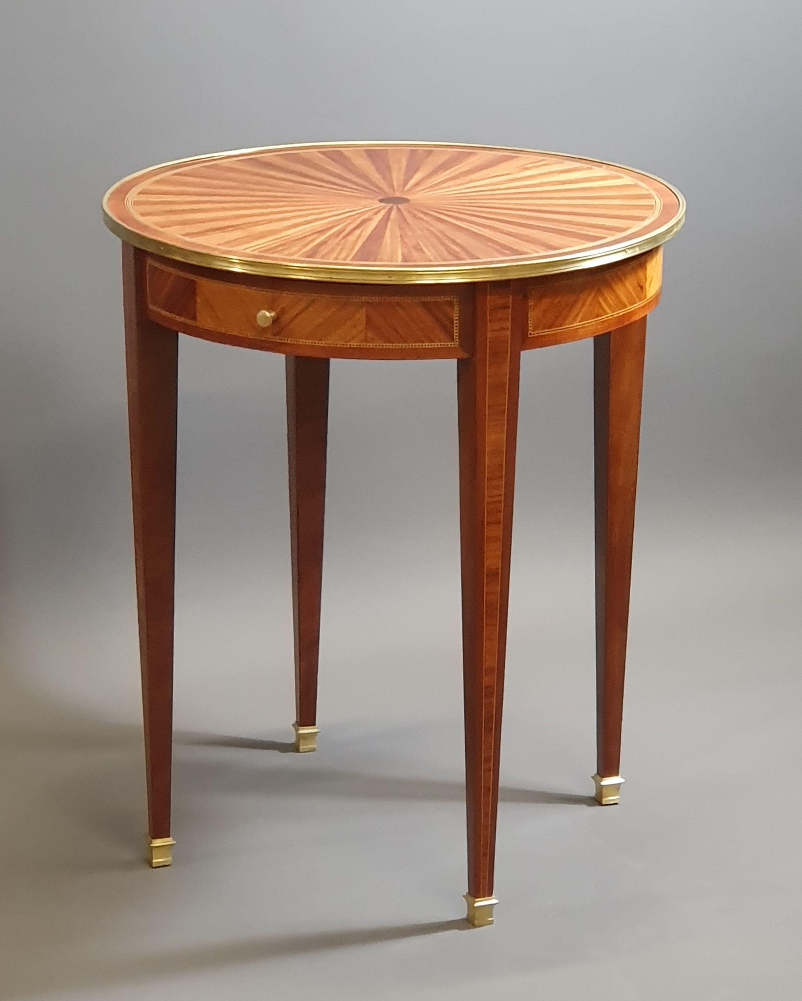 Elegant Louis XVI gueridon in rosewood and mahogany veneer resting on four sheathed legs and presenting a radiant marquetry top surrounded by a gilt bronze mold.
Nets in checkerboards of light wood and ebony on the belt and on the top.

Opening a