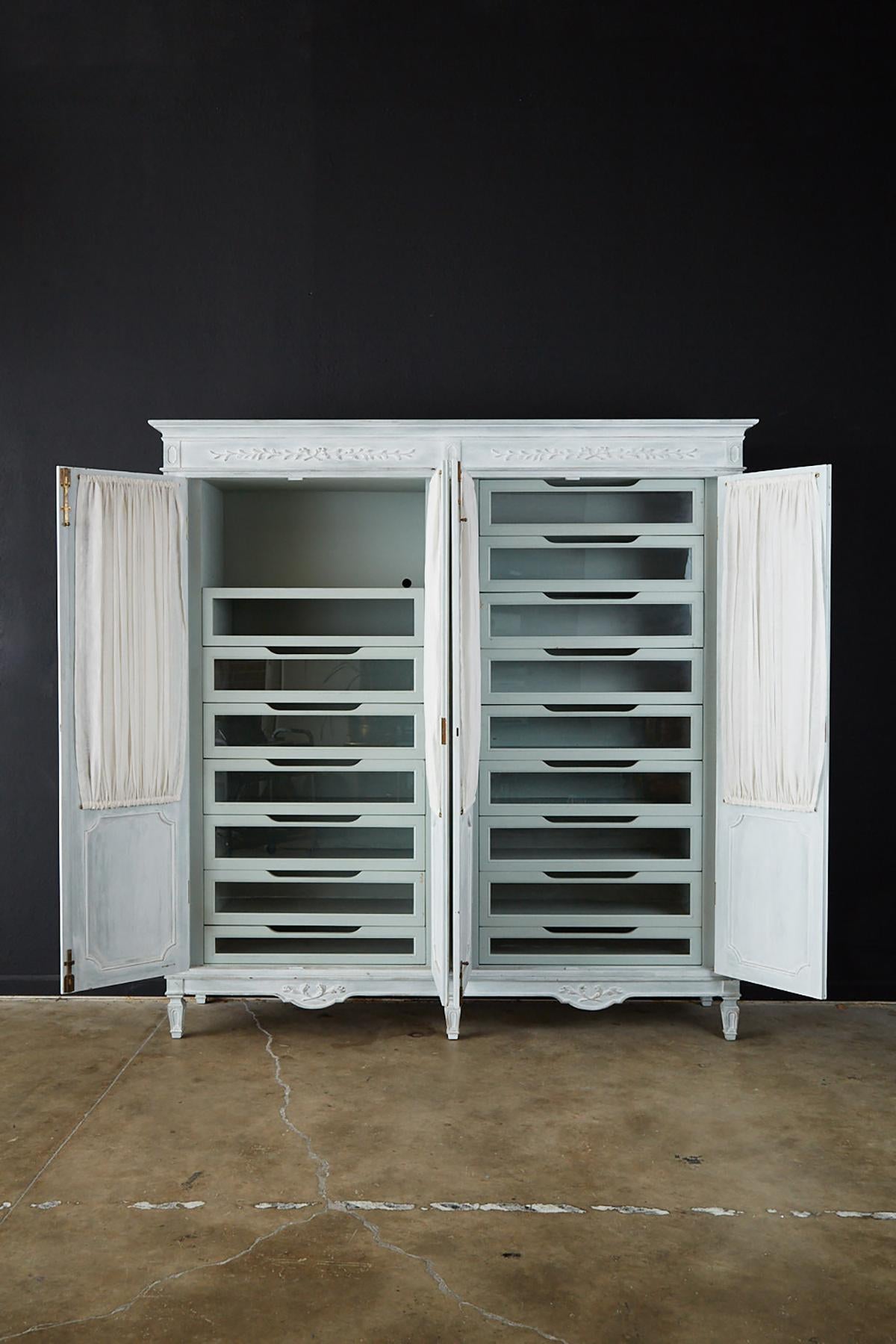 Grand four-door wardrobe or armoire made in the Louis XVI Gustavian taste. Bespoke piece finished in a light blue paint fronted by four large doors with period correct style brass hardware. Made of solid wood with numerous handcrafted details each