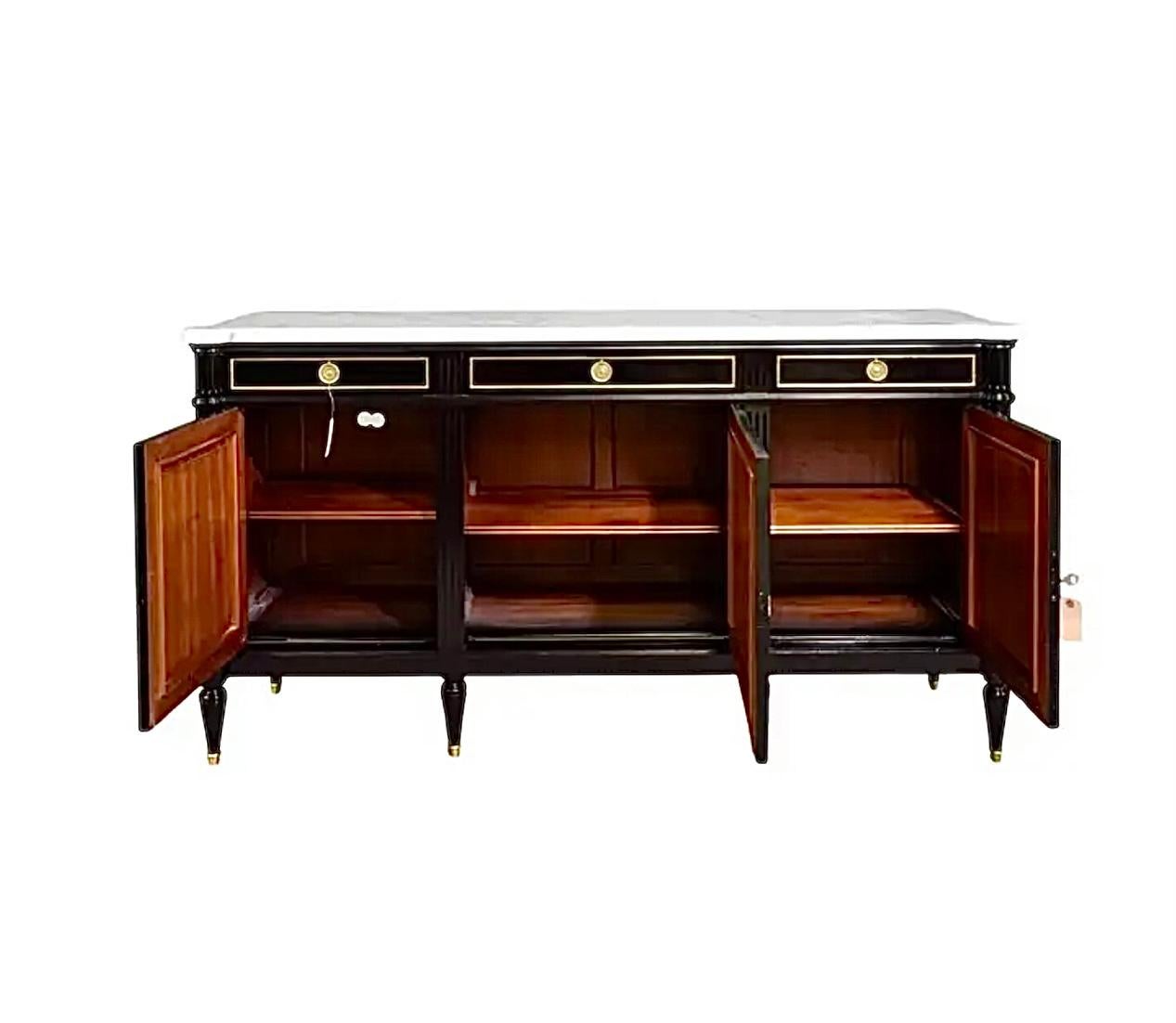 Louis XVI Hollywood Regency Maison Jansen Style French black sideboard enfilade with white marble top combines the neoclassical design with functional storage. The Louis XVI style, popular in the late 18th century and mid 20th century is