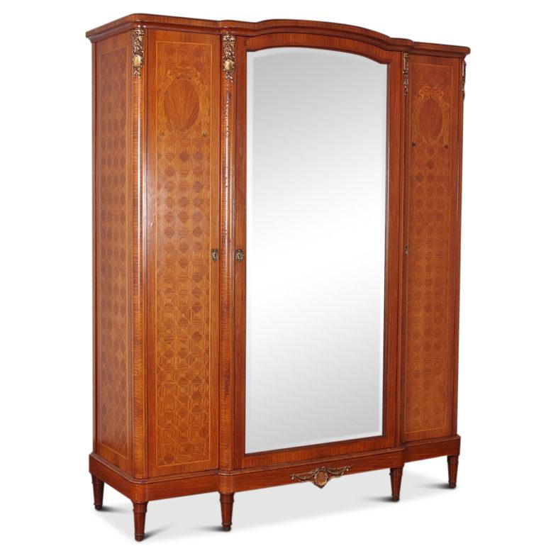 Fine-quality, French inlaid Louis XVI-style 3-door armoire, featuring inlaid classical motifs on a parquetry background. The interior has adjustable shelves on each side and a central section for hanging. There is a custom-fitted three-drawer chest