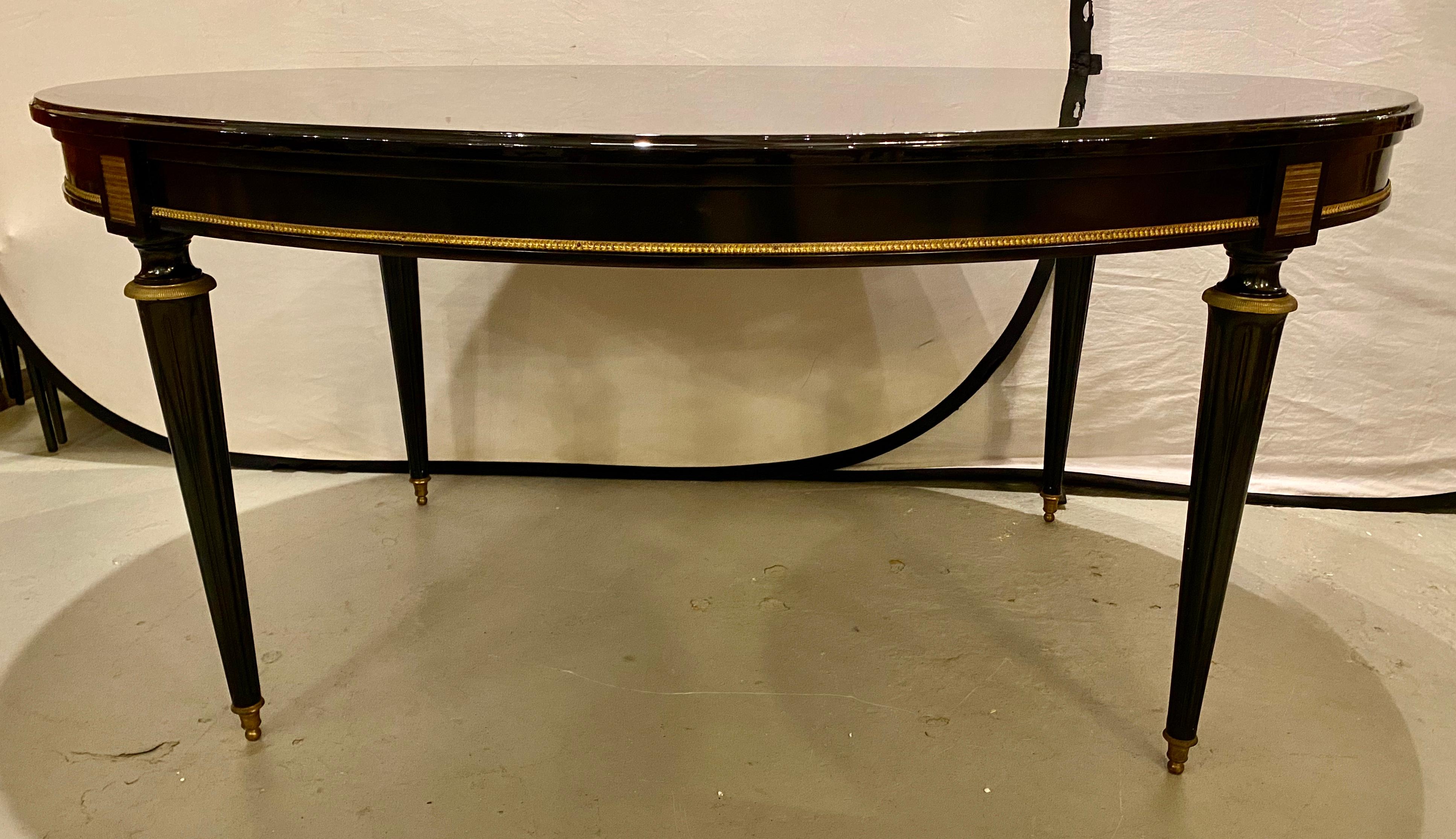 Louis XVI Jansen style center or dining table in a black lacquer Steinway piano finish. Part of our extensive collection of over forty dining tables and chair sets as seen on this site, thus why we are referred to as the King of Dining rooms.  All