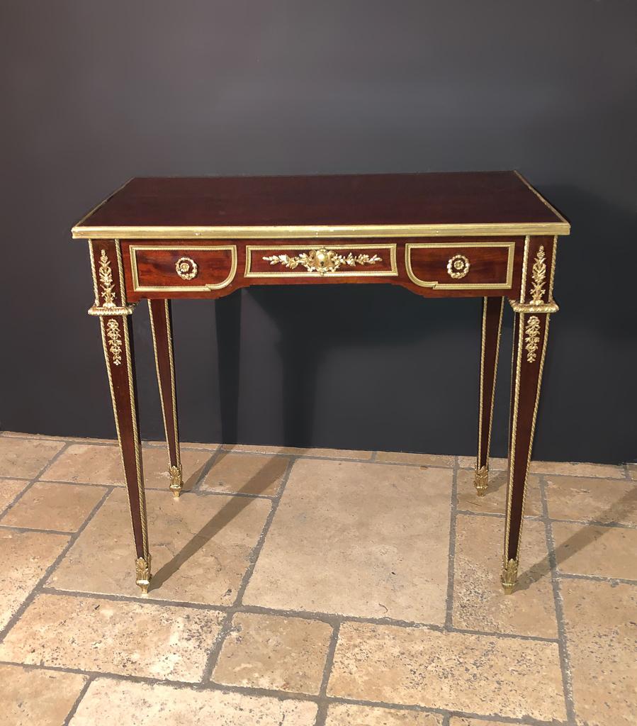 A fine French Louis XVI acajou lady's writing table with bronze ormolu mounts and trim, a large single frieze drawer on square tapered legs.