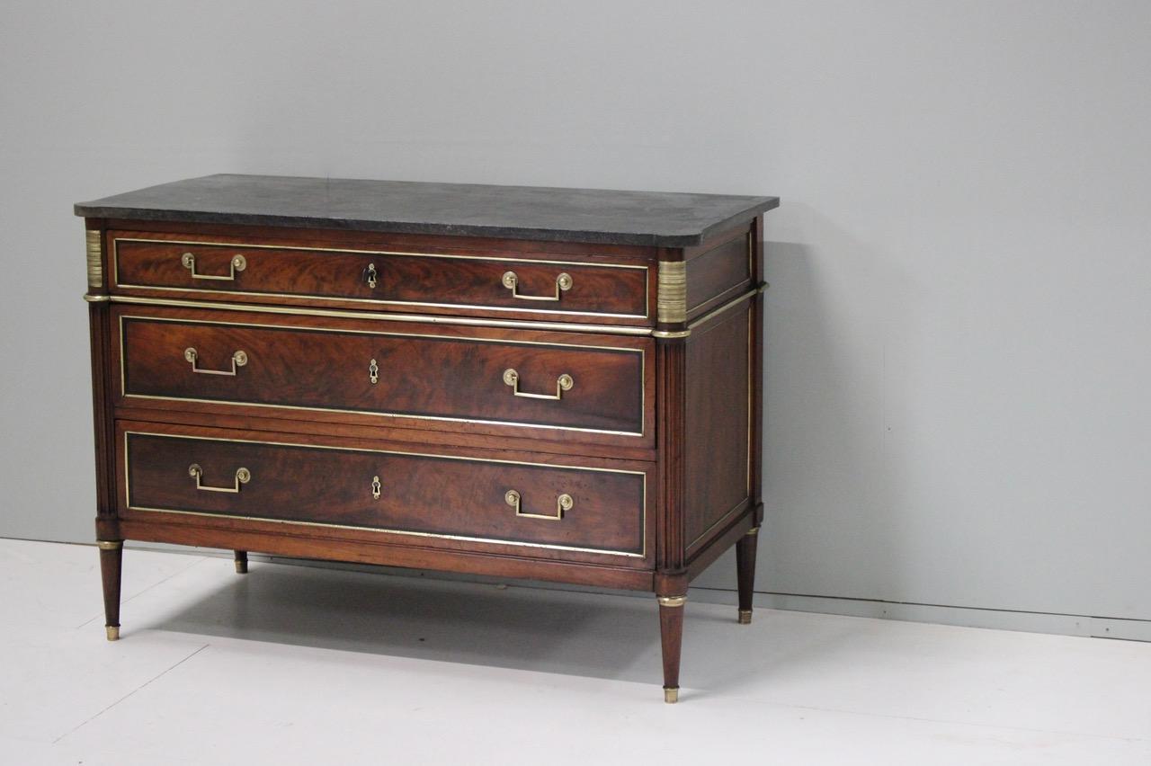 A fine quality and with a lovely color, late 18th century French mahogany and brass-mounted commode of elegant proportions, and retaining the original marble top, stamped N.Petit ( Parisian maker, Master in 1761 ).