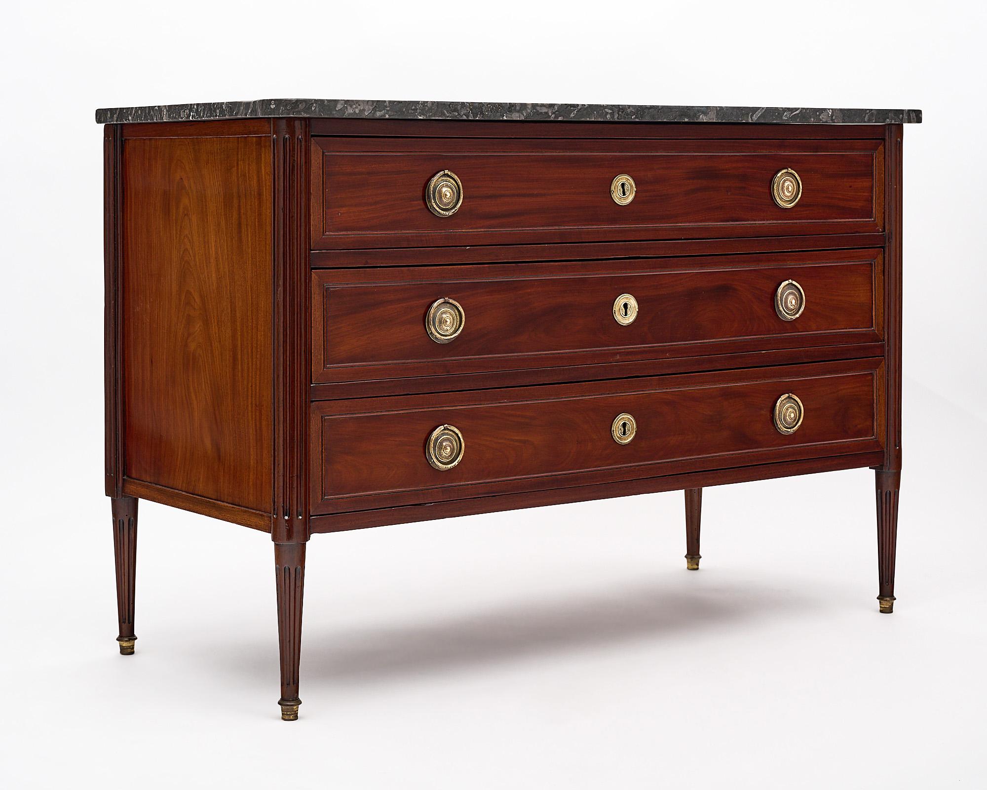Chest, French, from the Louis XVI period made of mahogany that has been finished with a lustrous French polish. This elegant commode features three dovetailed drawers with finely cast lost wax hardware and an intact, black, veined marble top.