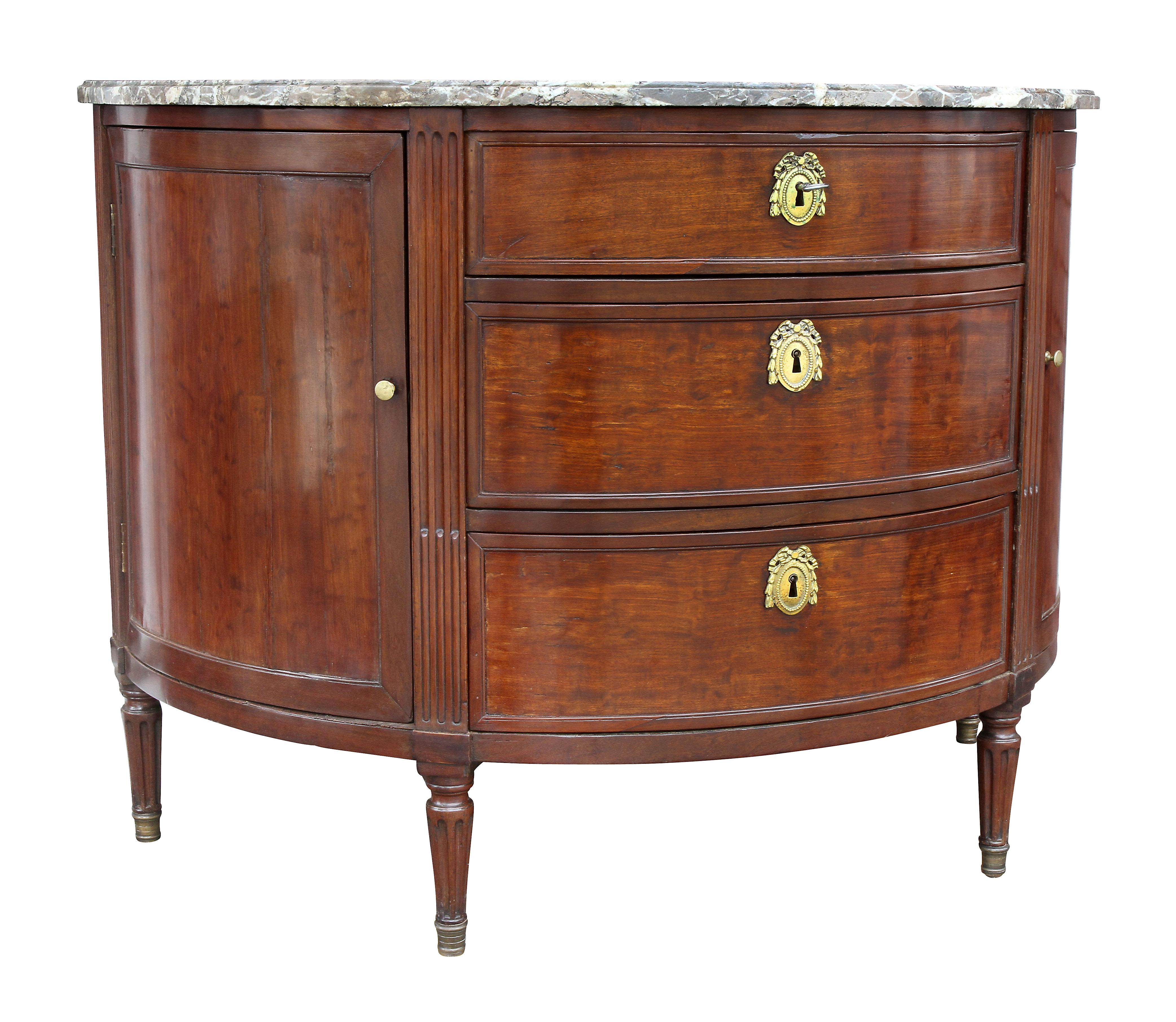 With D-shaped marble top over three graduated drawers flanked by stop fluting and paneled doors, raised on circular fluted tapered legs with sabot feet. Provenance; Estate of William Hodgins, noted interior designer from Boston.