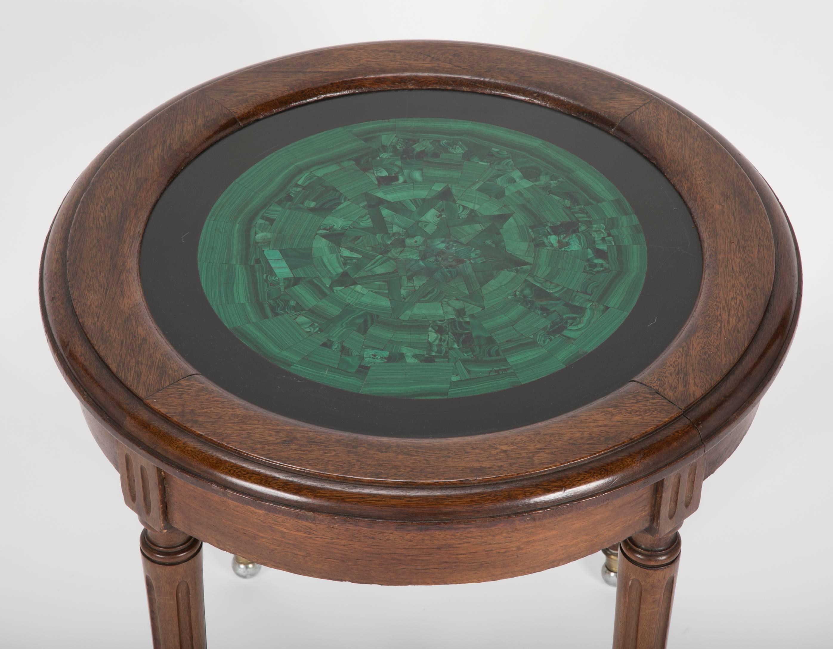 French Louis XVI style mahogany side table with a inlaid malachite top framed in polished black marble, supported by four reeded legs on bronze and steel ball feet The malachite top with an eight pointed star design.