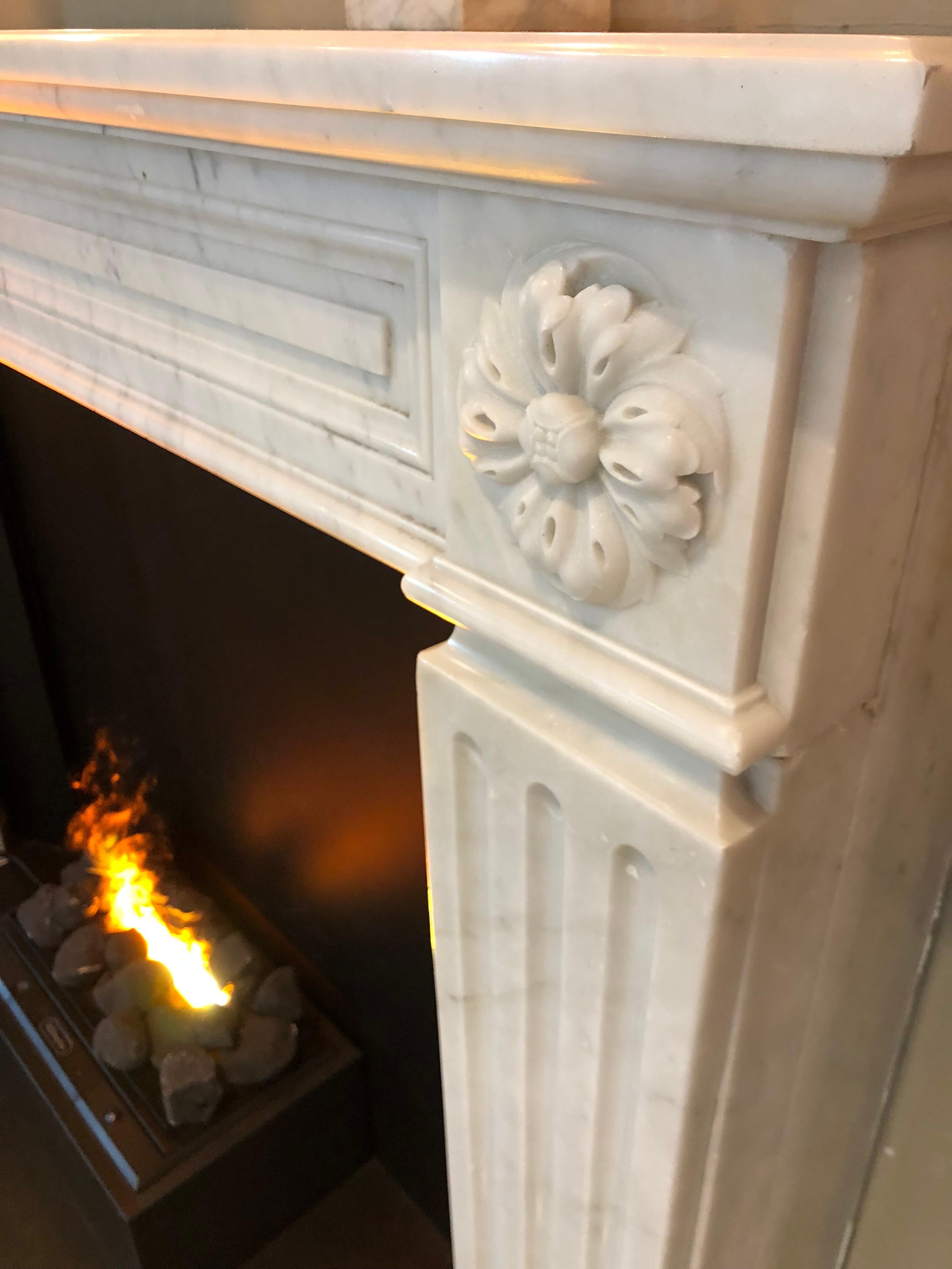 A Louis XVI design in Carrara marble with carved flower corner blocks, sitting above cabled fluting pilaster legs.

Opening dimensions: 43 1/2