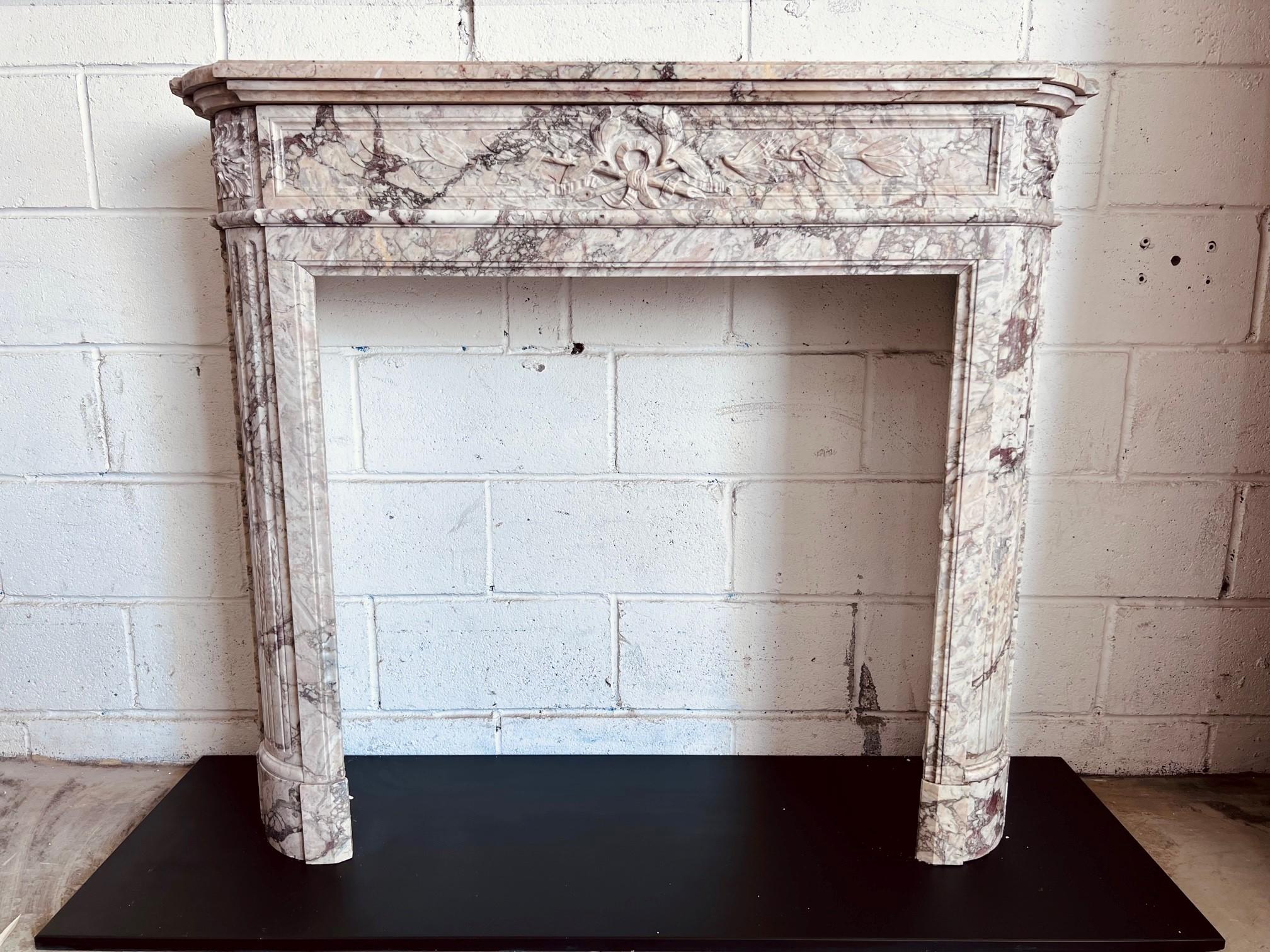 Louis XVI Style Mantel in Breccia Rosa Marble with wreath and ribbon carving detail and rosette corner blocks.
Opening Dimensions 31 5/8