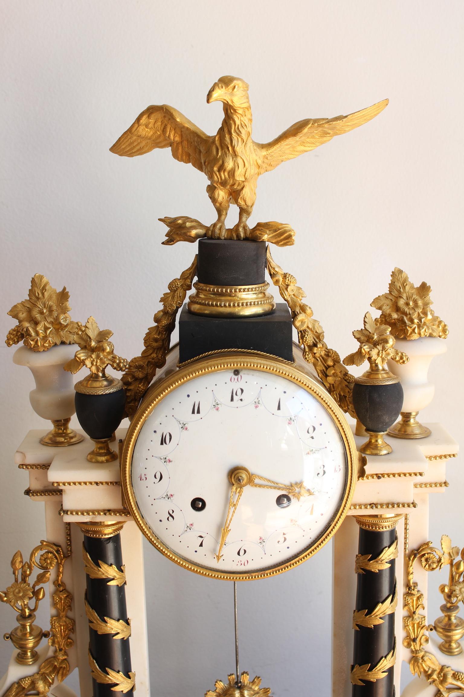 A Louis XVI Mantel set comprising a white and black marble clock with gilded bronze decorations and a gilded bronze eagle on top, and two Putti candelabras.
Very good condition. The mechanism of the clock has been revised by a