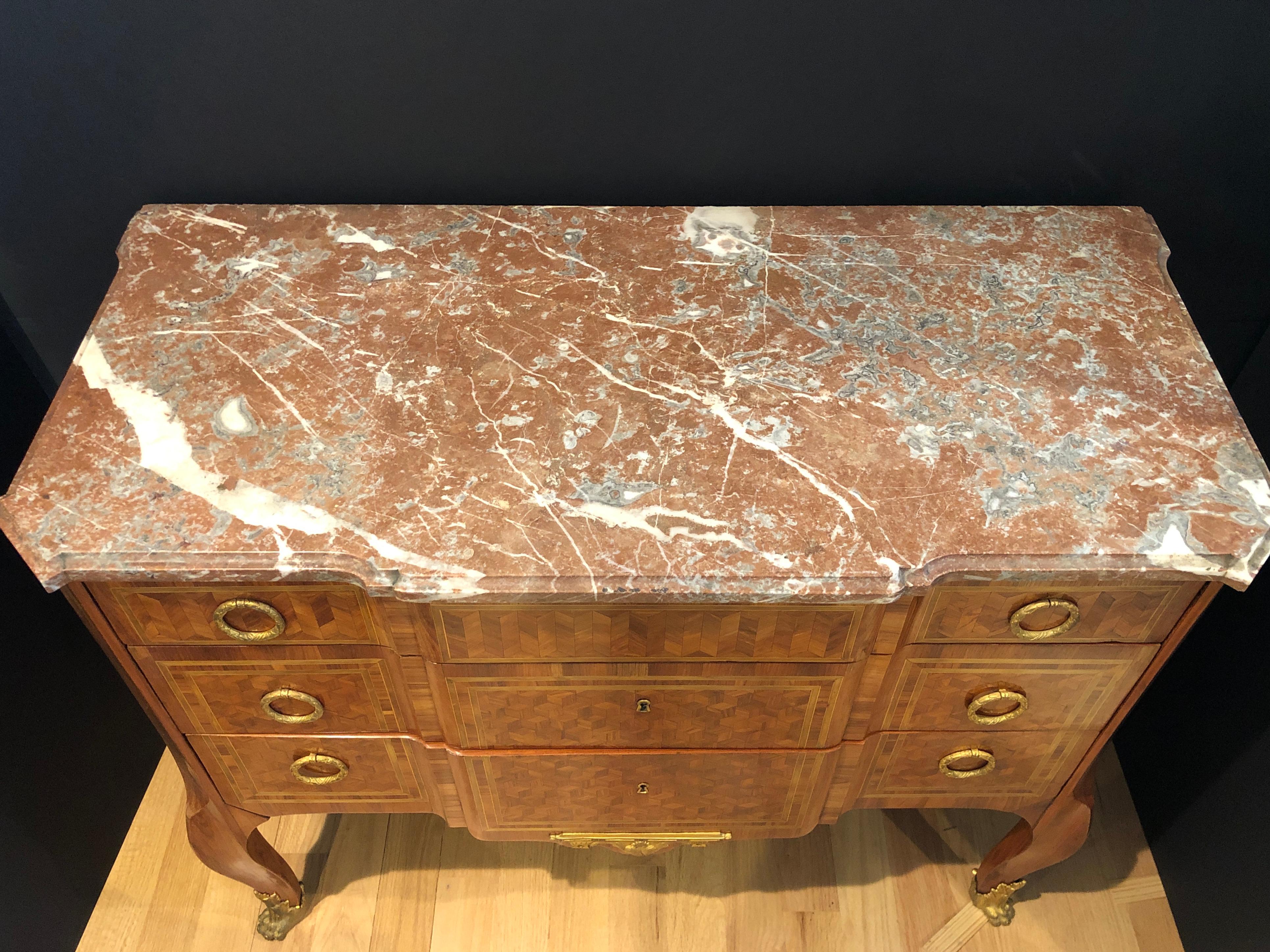 French 19th century Louis XVI marble-top marquetry commode. Remarkable parquetry inlay work defines this mahogany and kingwood commode. A beautifully mottled marble top, block front, and deeply chamfered front corners are welcome design elements