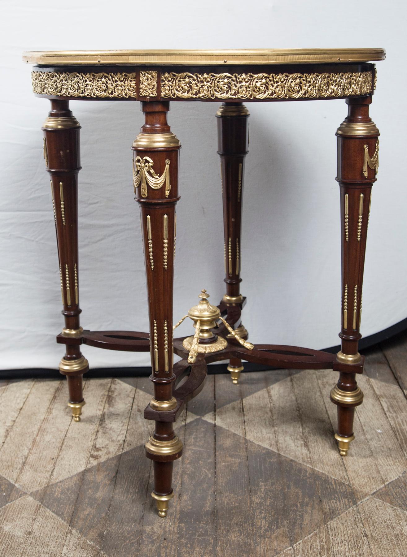 Breche violette marble top with gilt bronze mounts. The four legs attached to an unusual stretcher. topped with an urn shaped finial and four supports.